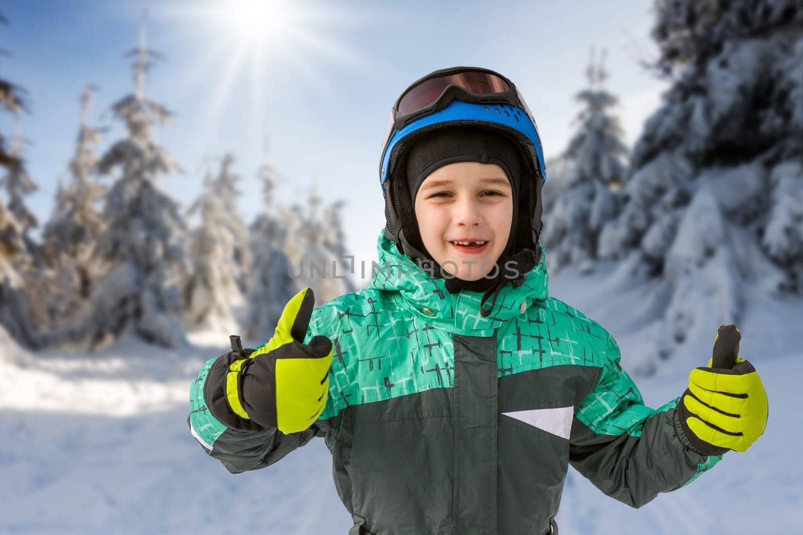 little boy on mountains in ski helmet with fallen first tooth, Czech Republic