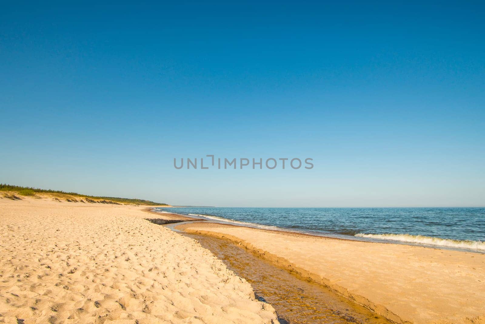 lonesome beach of the Baltic Sea with blue sky