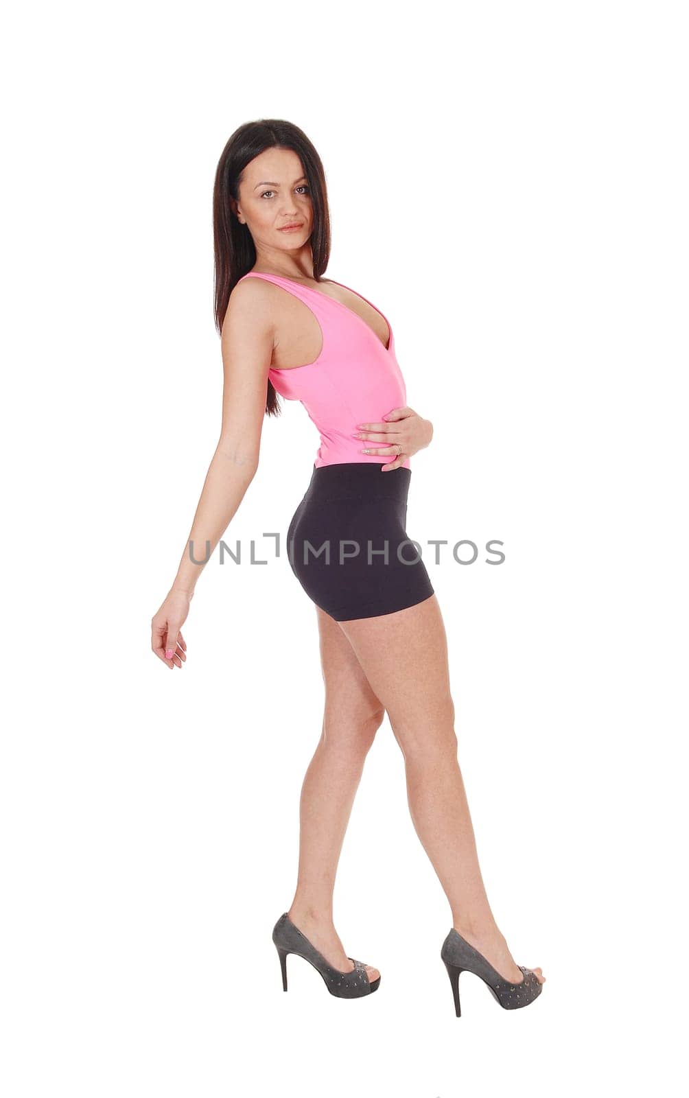 Beautiful slim young woman standing in the studio in profile.bending backwards, isolated for white background.
