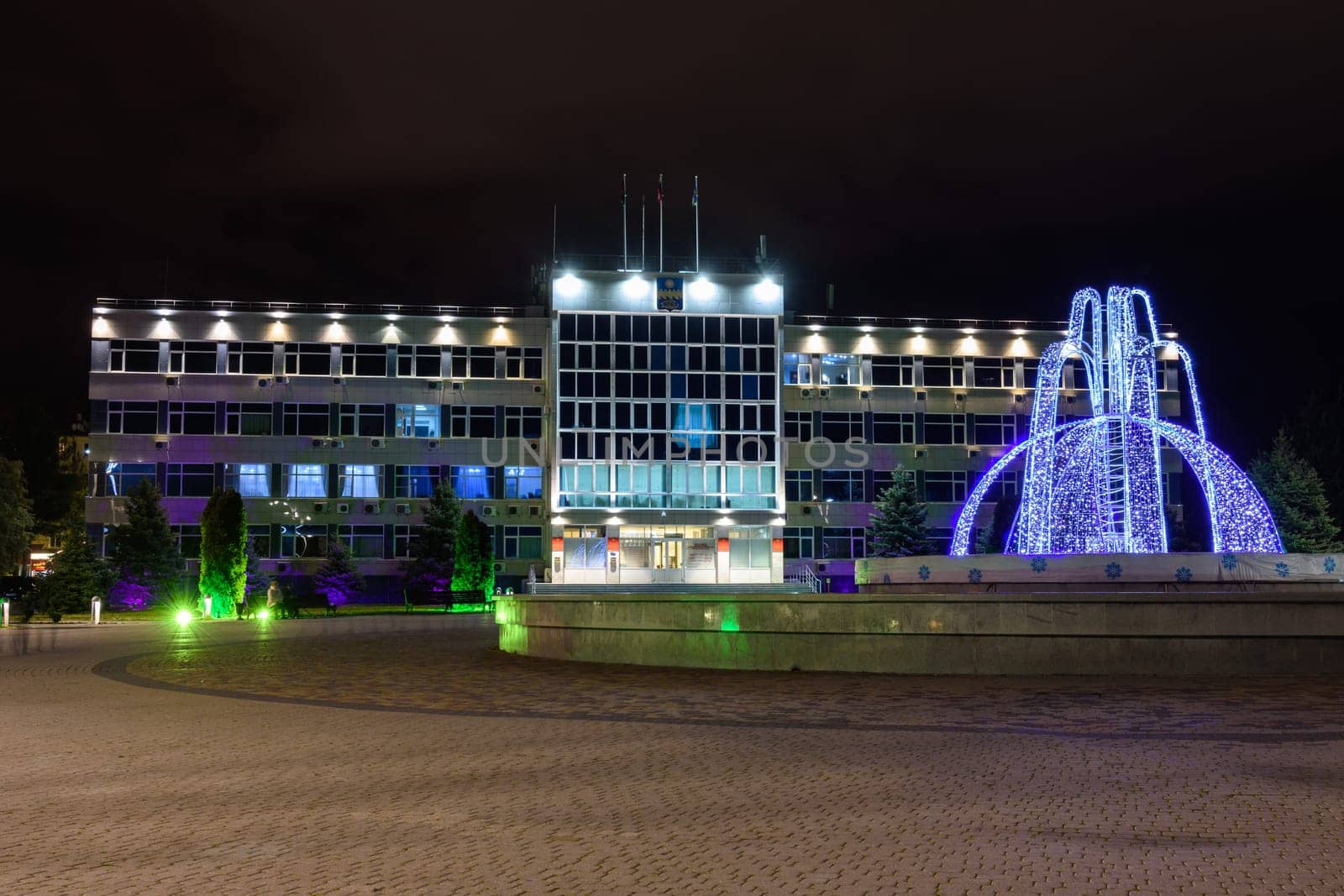 Anapa, Russia - February 28, 2020: View of the administration of Anapa and the winter fountain in front of it after sunset