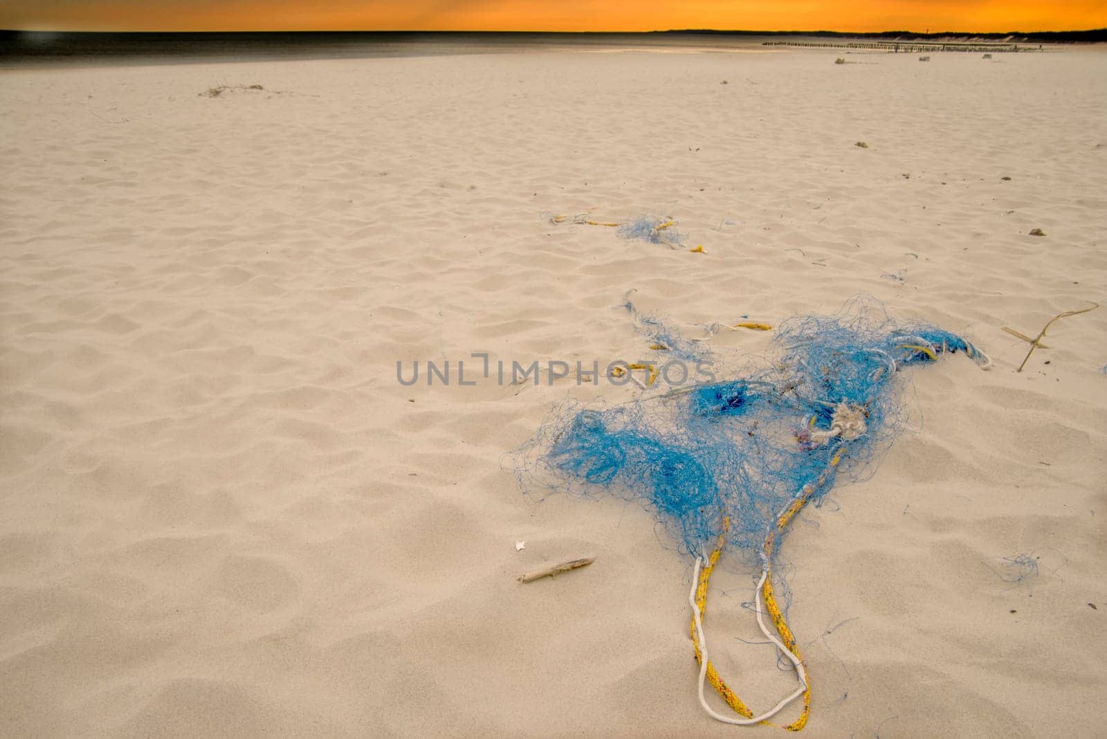 old fishing net on a beach with dramatic sky