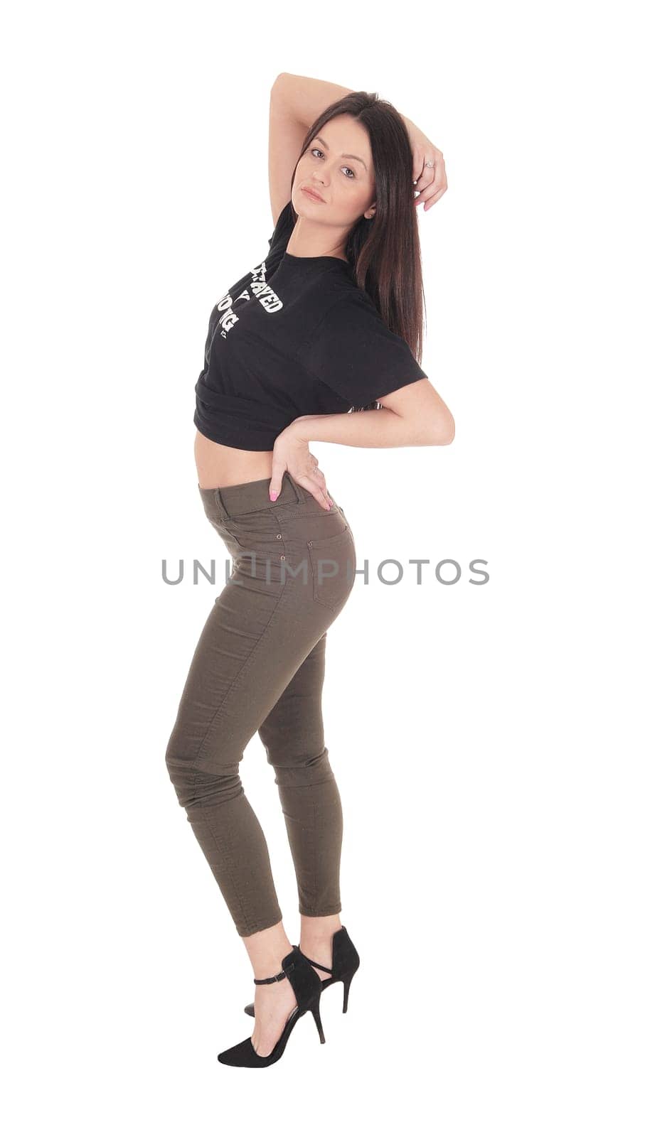 Beautiful slim young woman standing in the studio in profile, looking .looking into the camera, bending back, isolated for white background.
