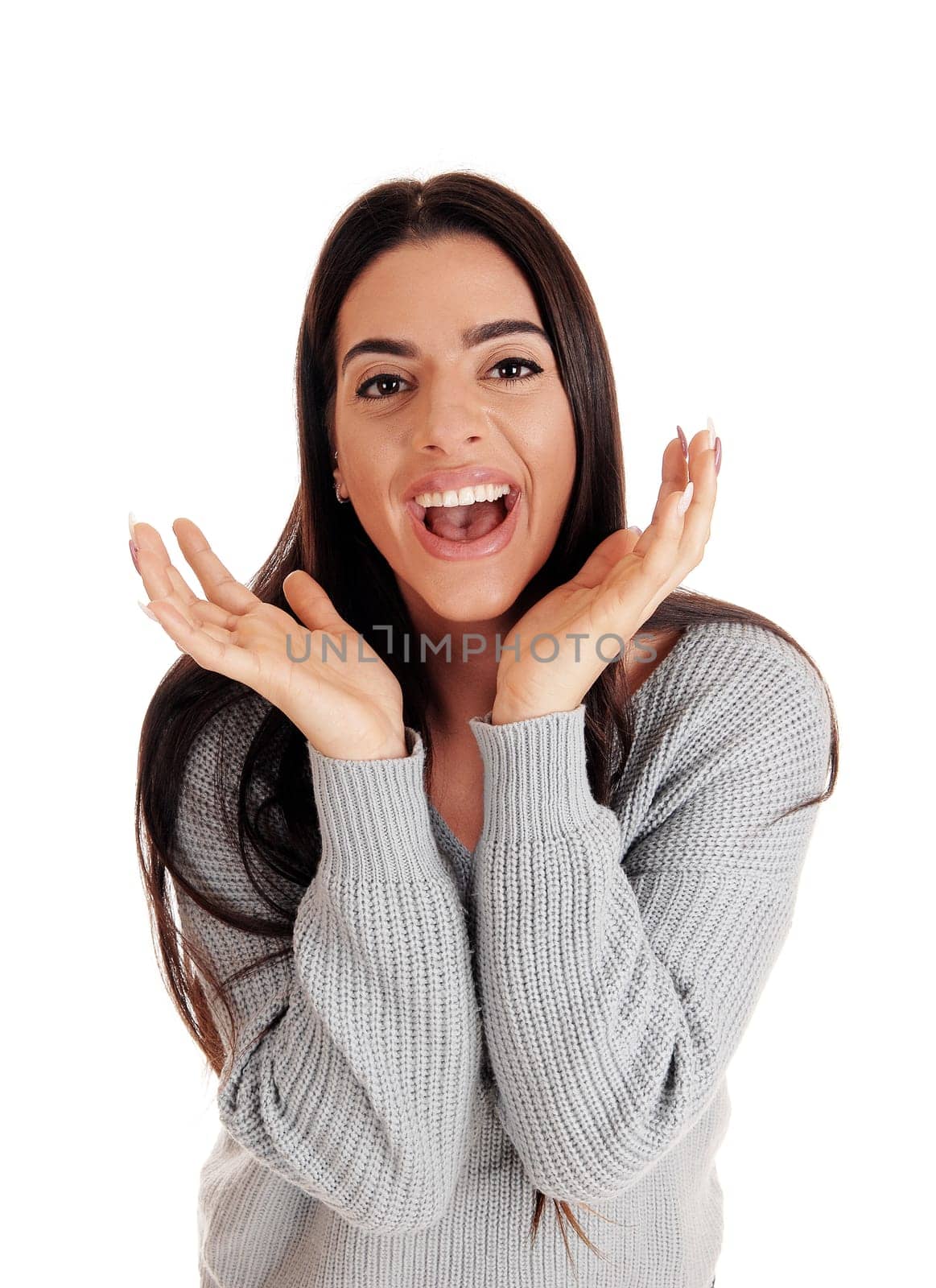 A beautiful young smiling woman standing in the studio with her hands.on her face and smiling happily, Isolated for white background.