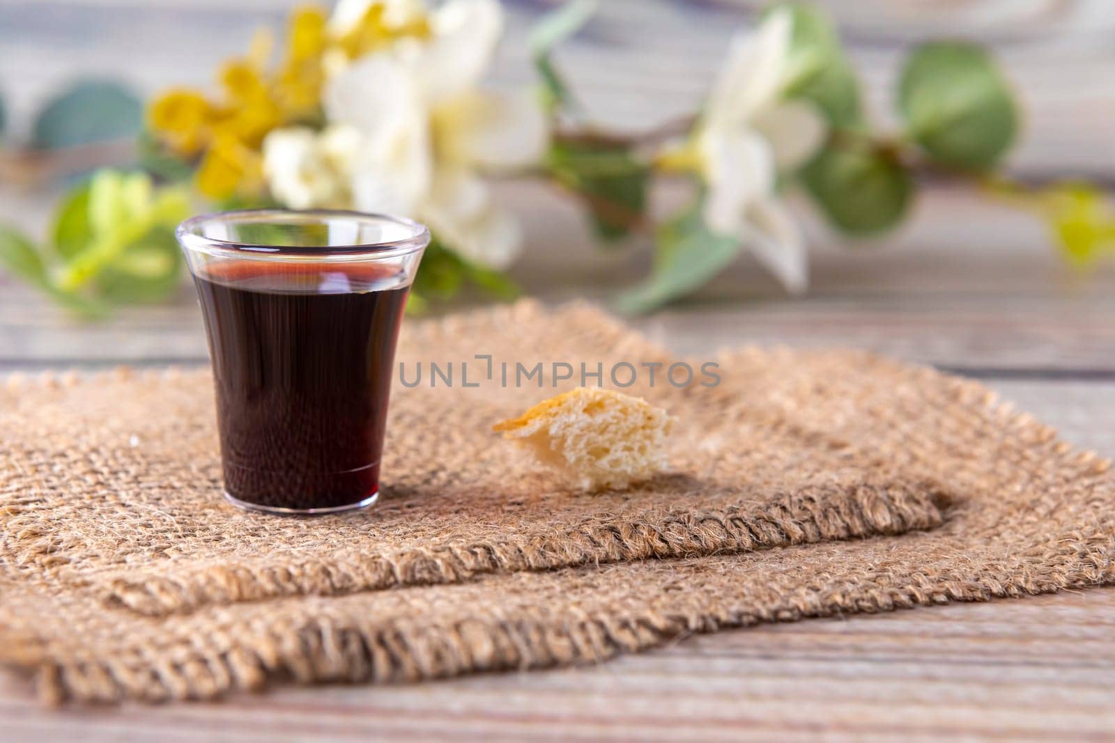 Taking communion concept - the wine and the bread symbols of Jesus Christ blood and body. Easter Passover and Lord . Focus on glass.