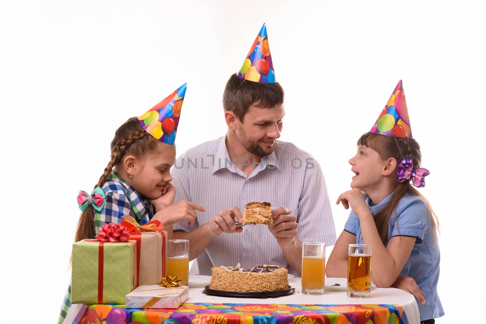Dad offers one of his daughter a piece of festive cake