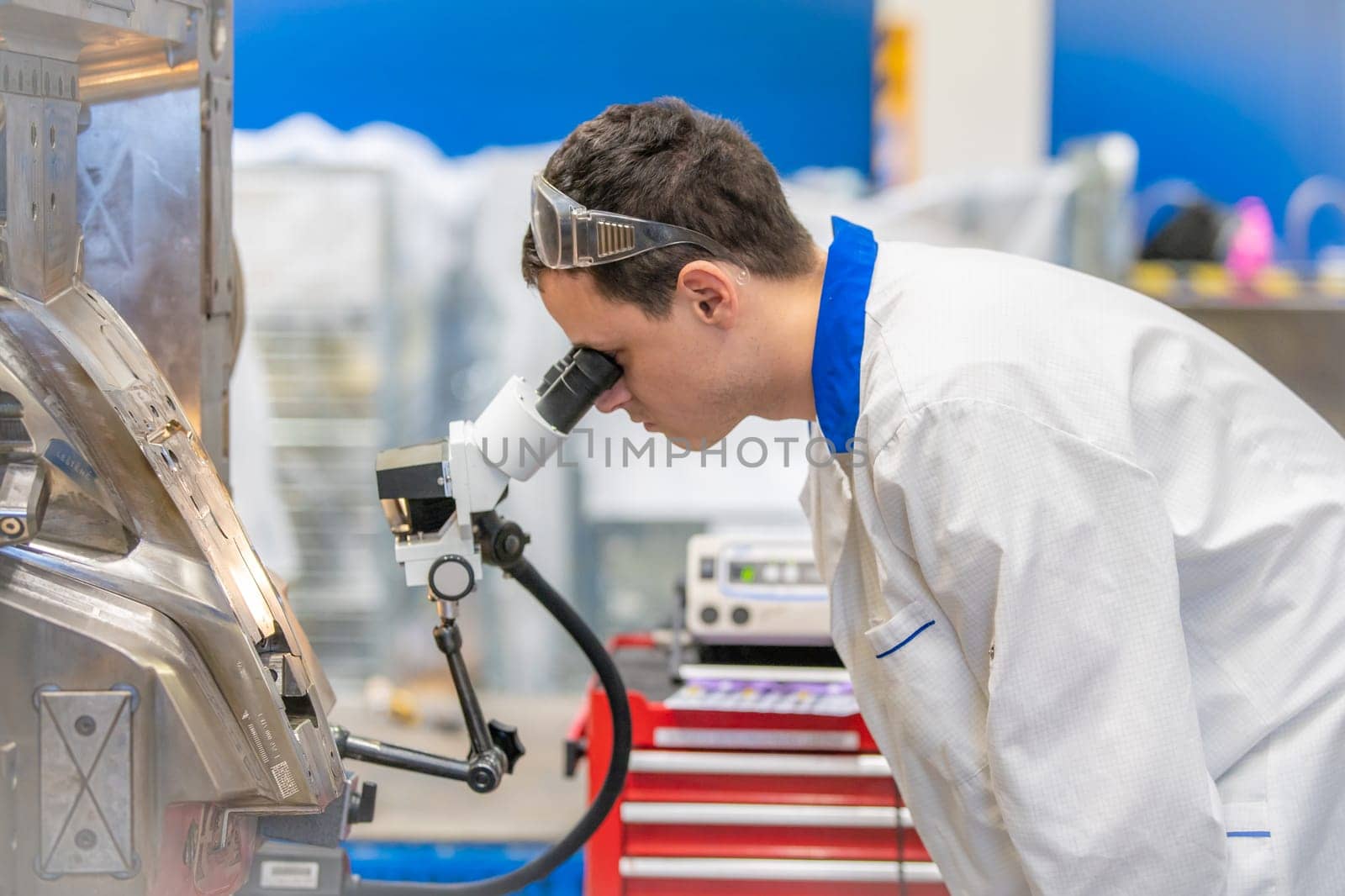 using a microscope while working in a research center.