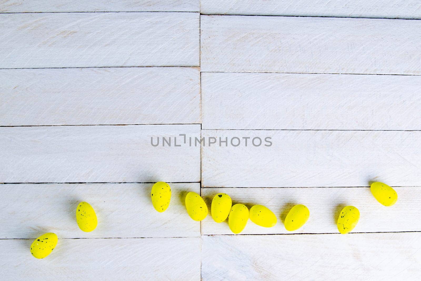 Easter concept. Yellow eggs stand on a white wooden table.