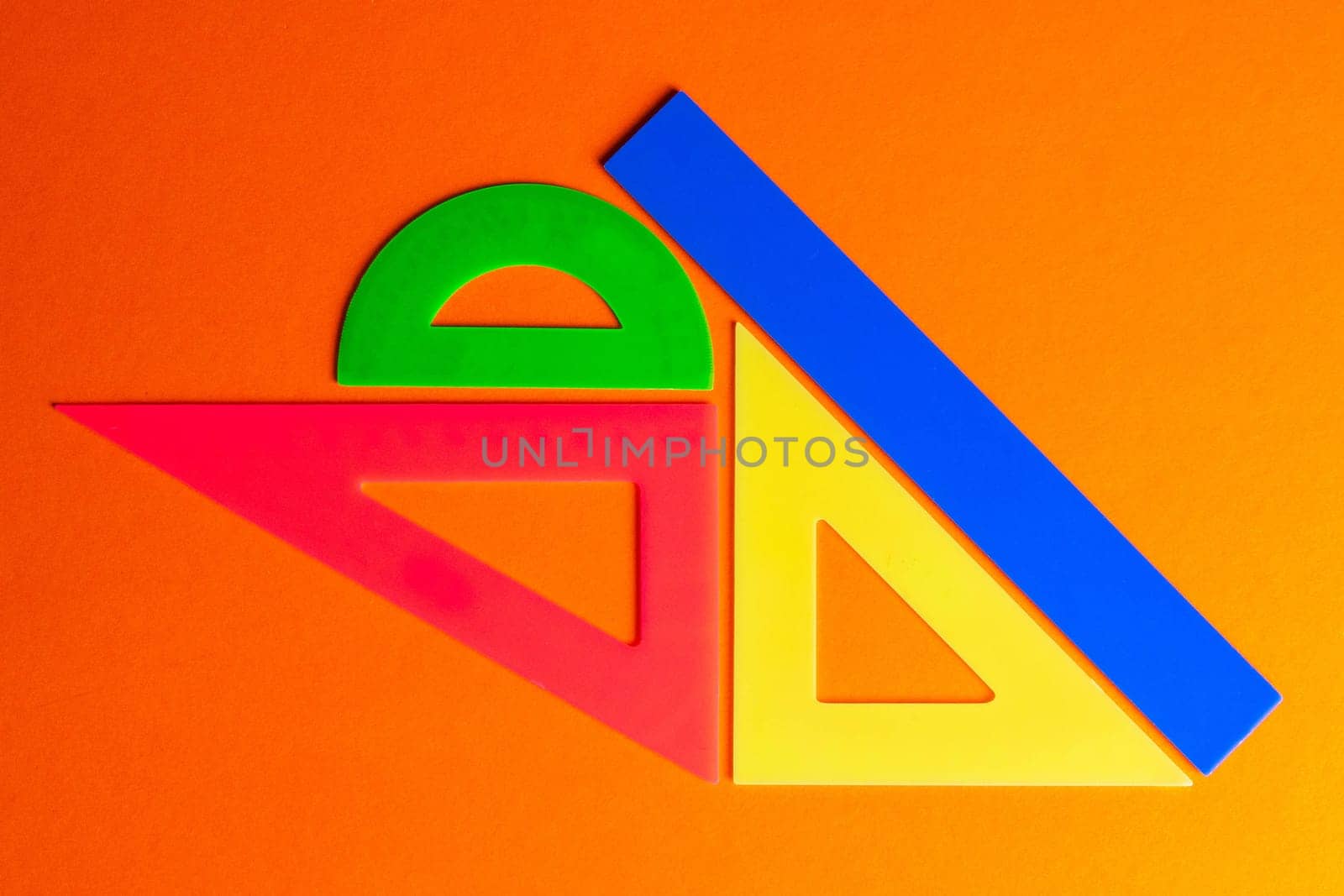 Back to school. Multicolored rulers on a black background. Copy space for text.
