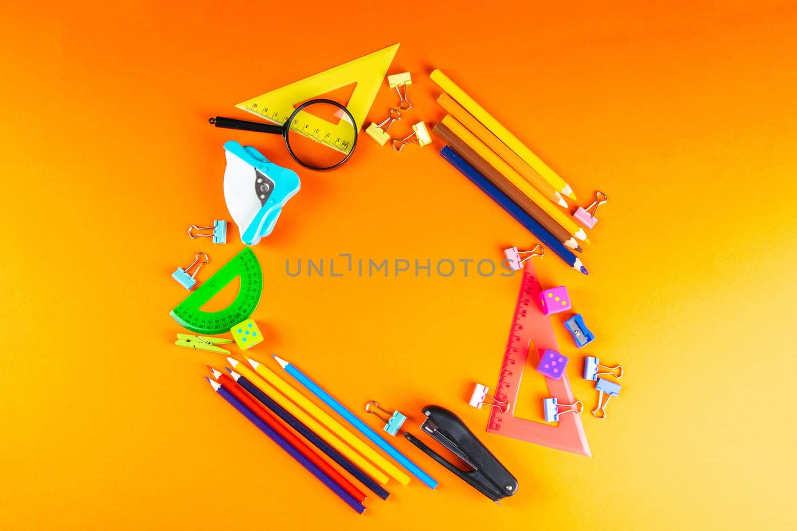 Background texture: school stationery on the orange desk. Stationery for the office, free space for writing. Concept: back to school, scissors and paper, office supplies.