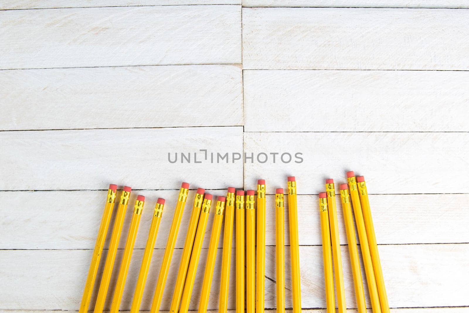 A set of orange pencils on a white wooden table. Printing supplies.