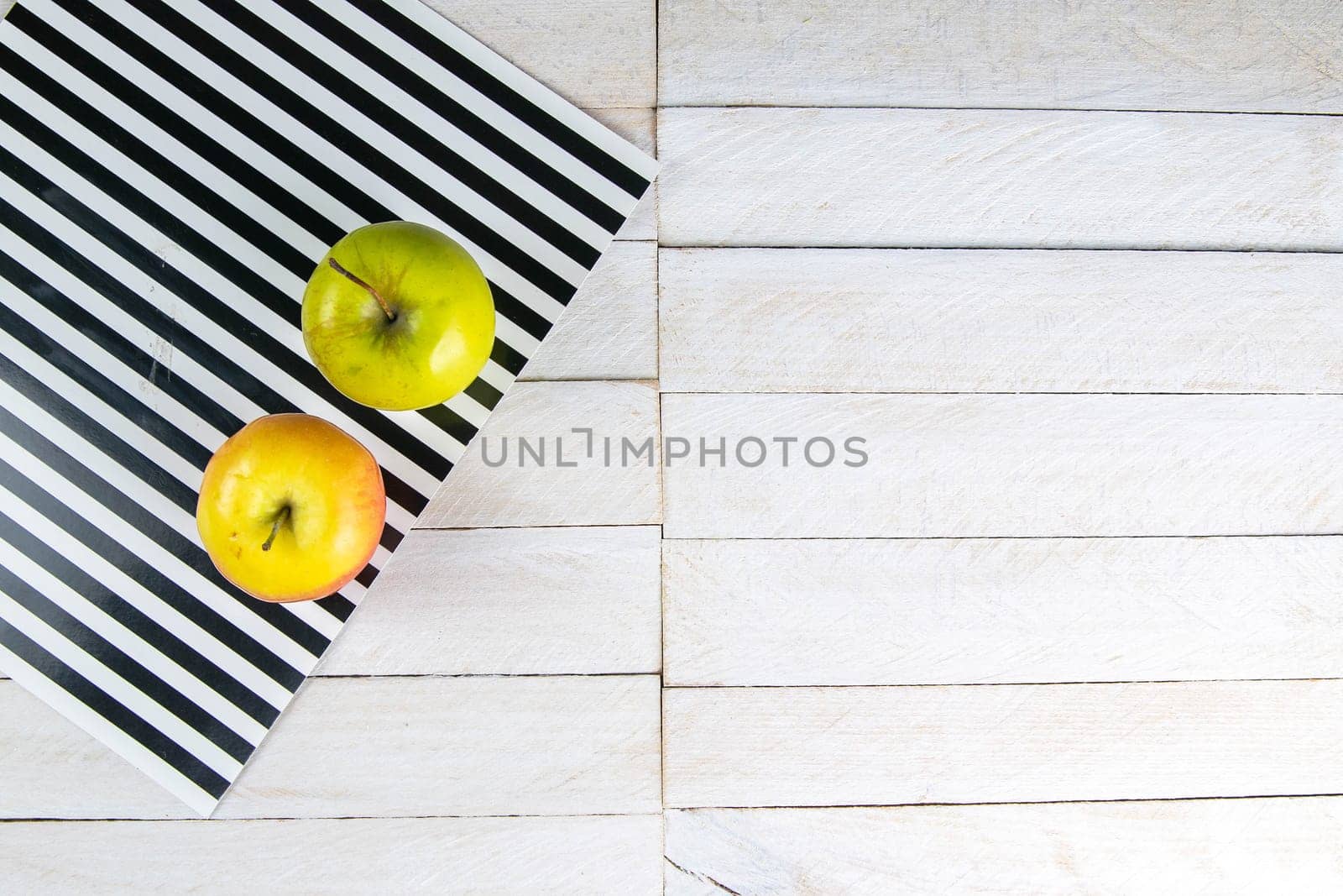 Two apple on white wooden garden or park table.