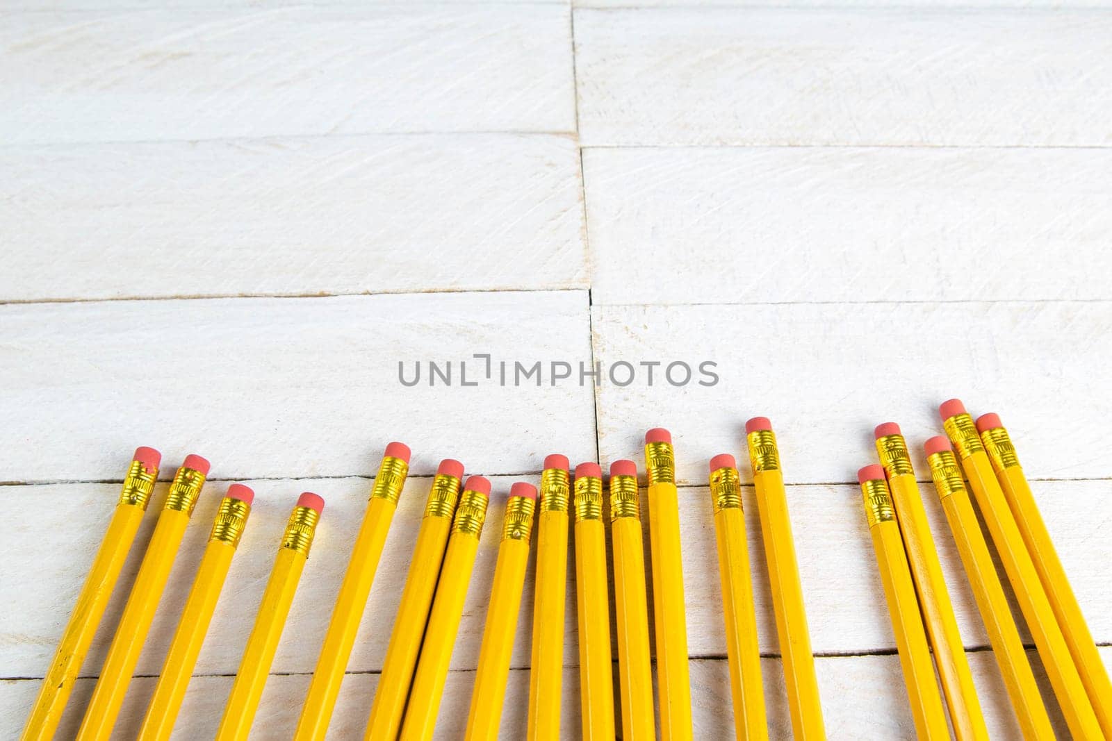 A set of orange pencils on a white wooden table. Printing supplies.