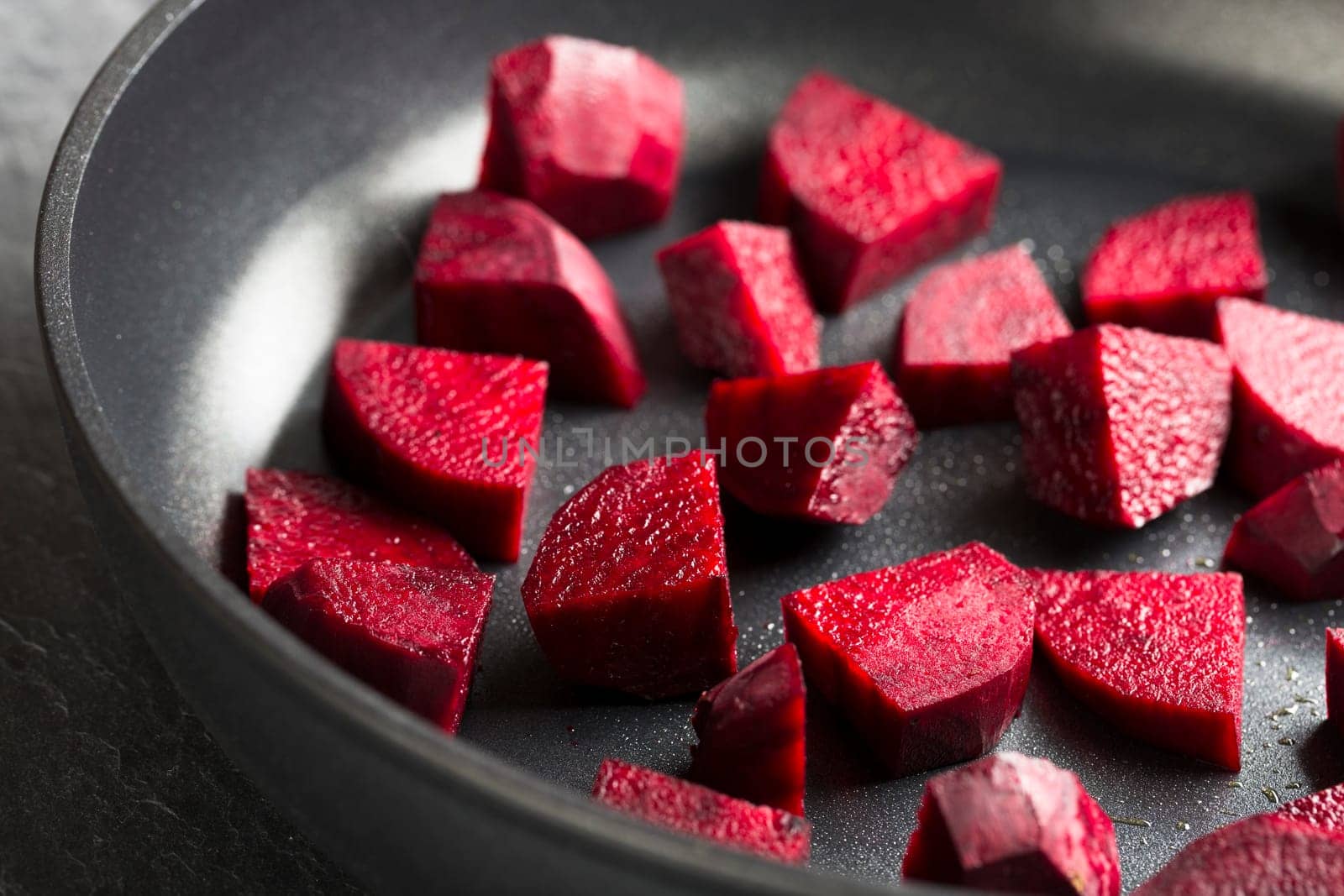 Cut beetroot in pan for cooking.