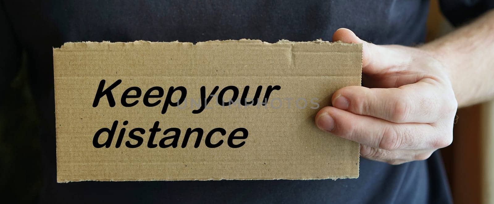 Cardboard sign with the inscription "keep your distance"""