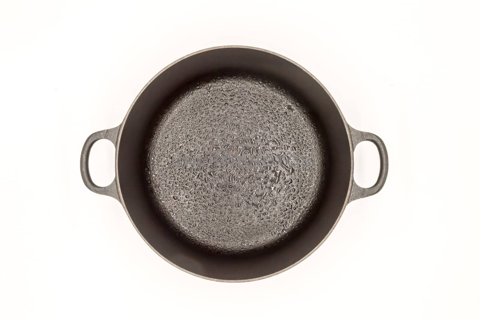 Cast iron pan with two handles top view on a white background
