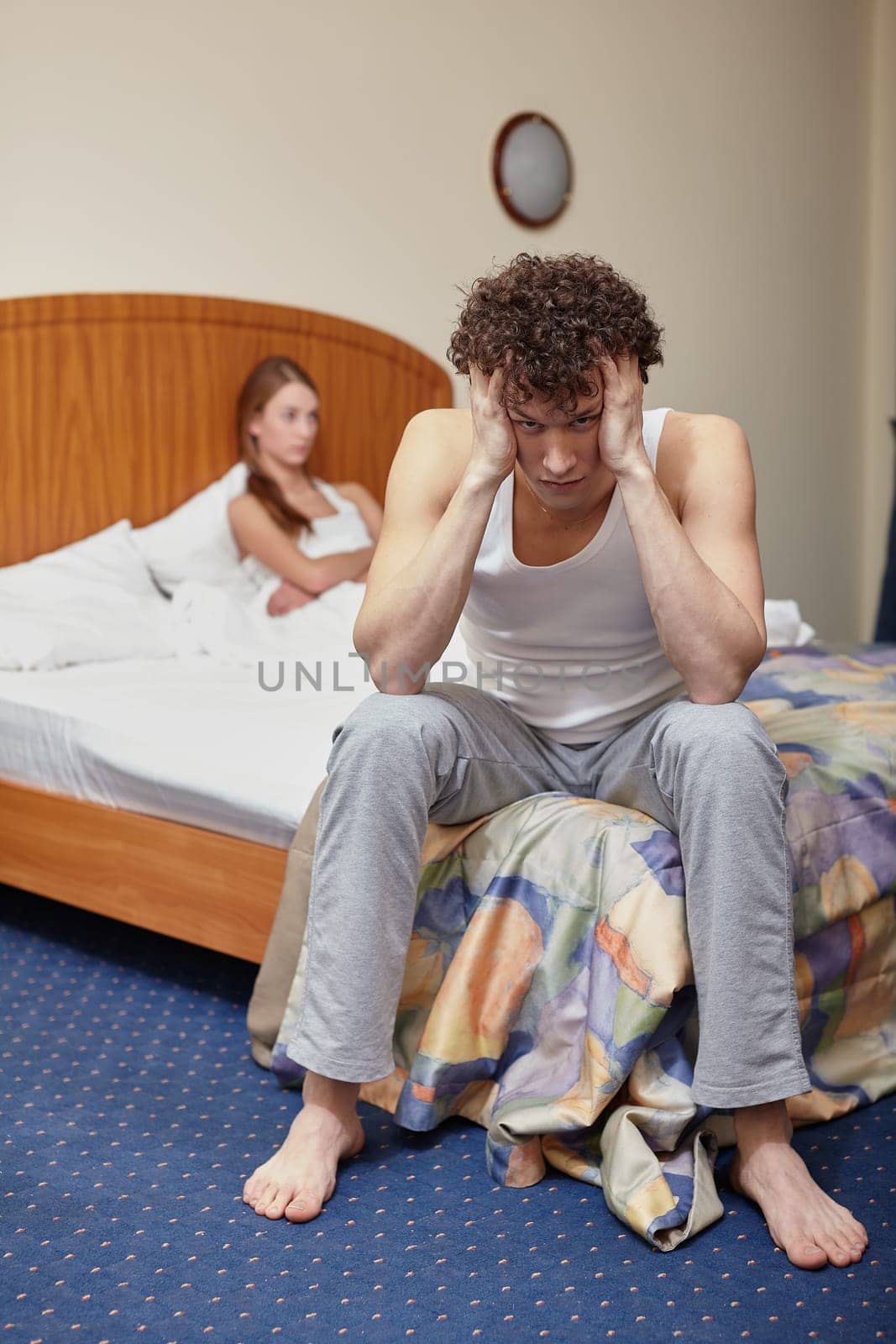 Family problems. Young couple quarrels in bedroom at home. Family conflict. Selective focus on man