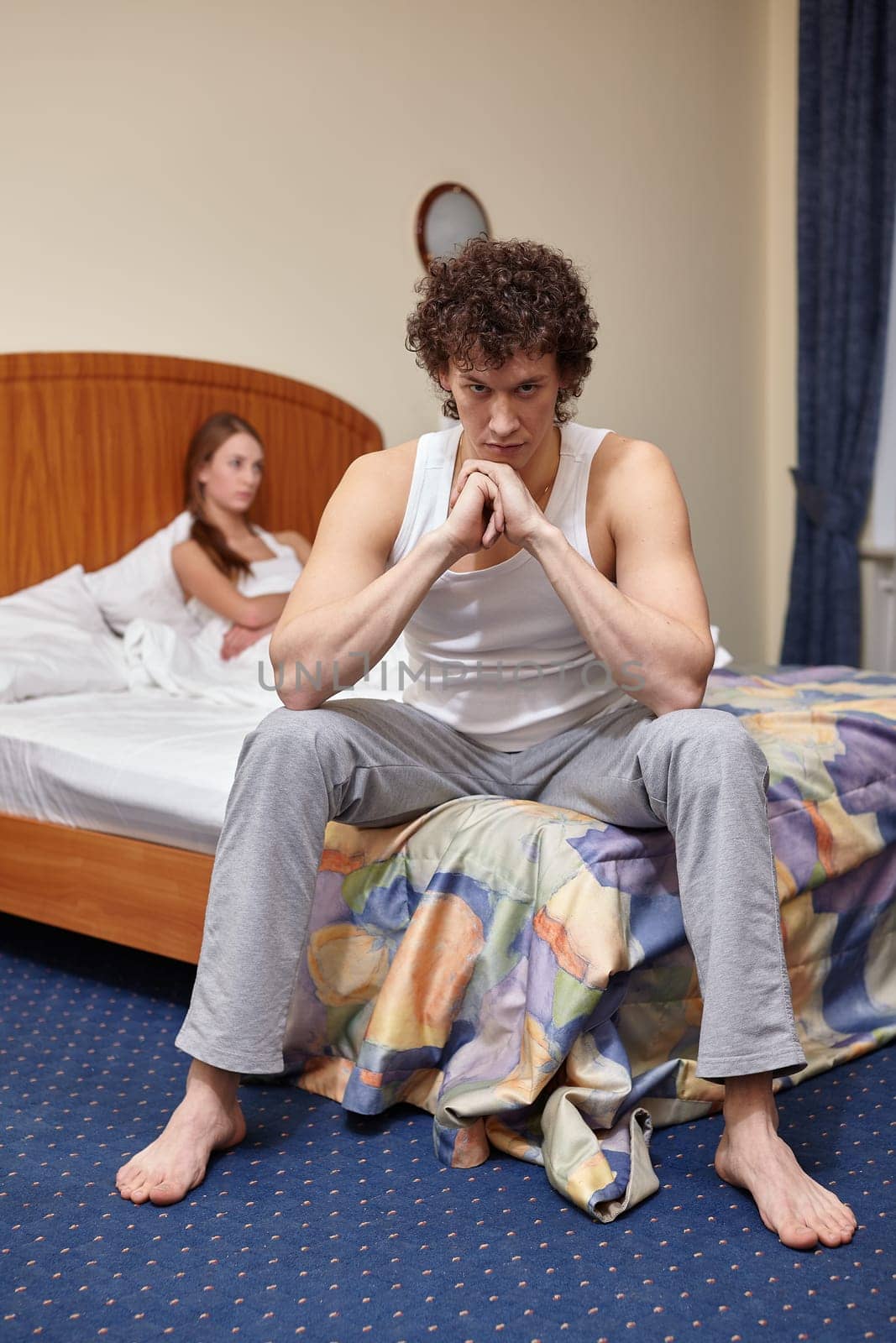 Family problems. Young couple quarrels in bedroom at home. Family conflict. Selective focus on man