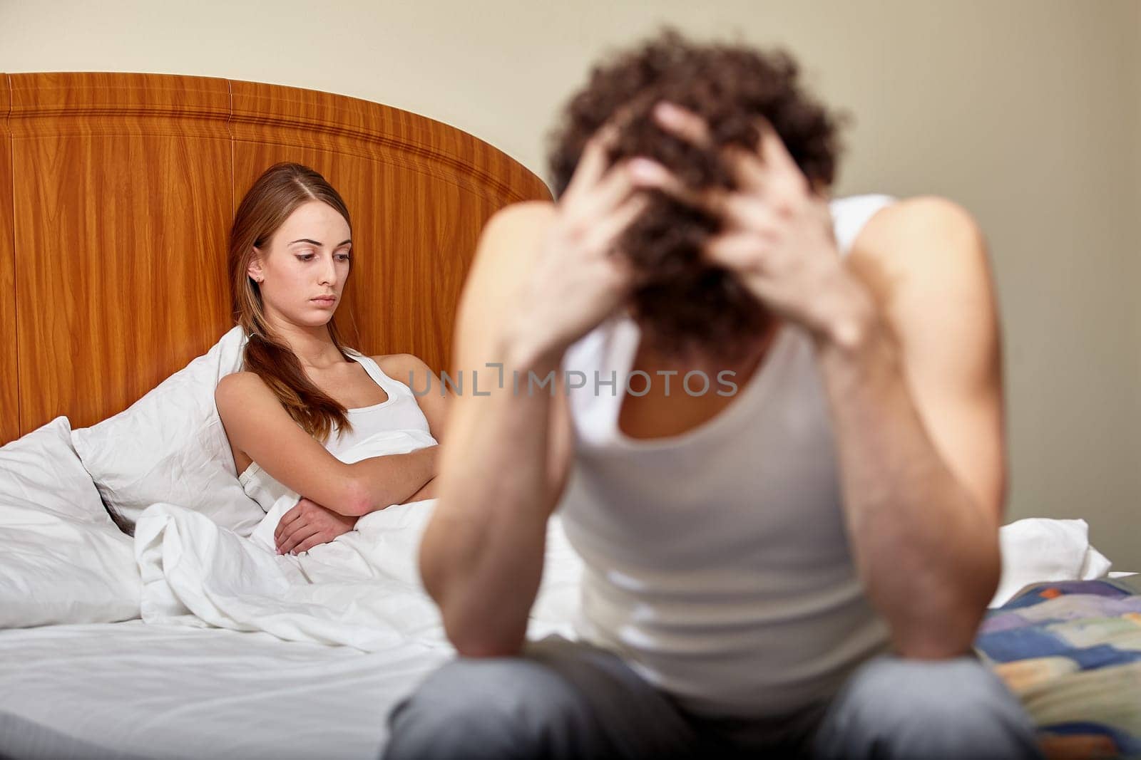 Family problems. Young couple quarrels in bedroom at home. Family conflict. Selective focus on woman
