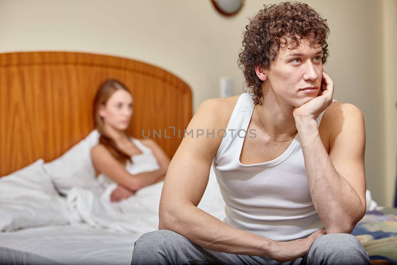 Family problems. Young couple quarrels in bedroom at home. Family conflict. Selective focus on man
