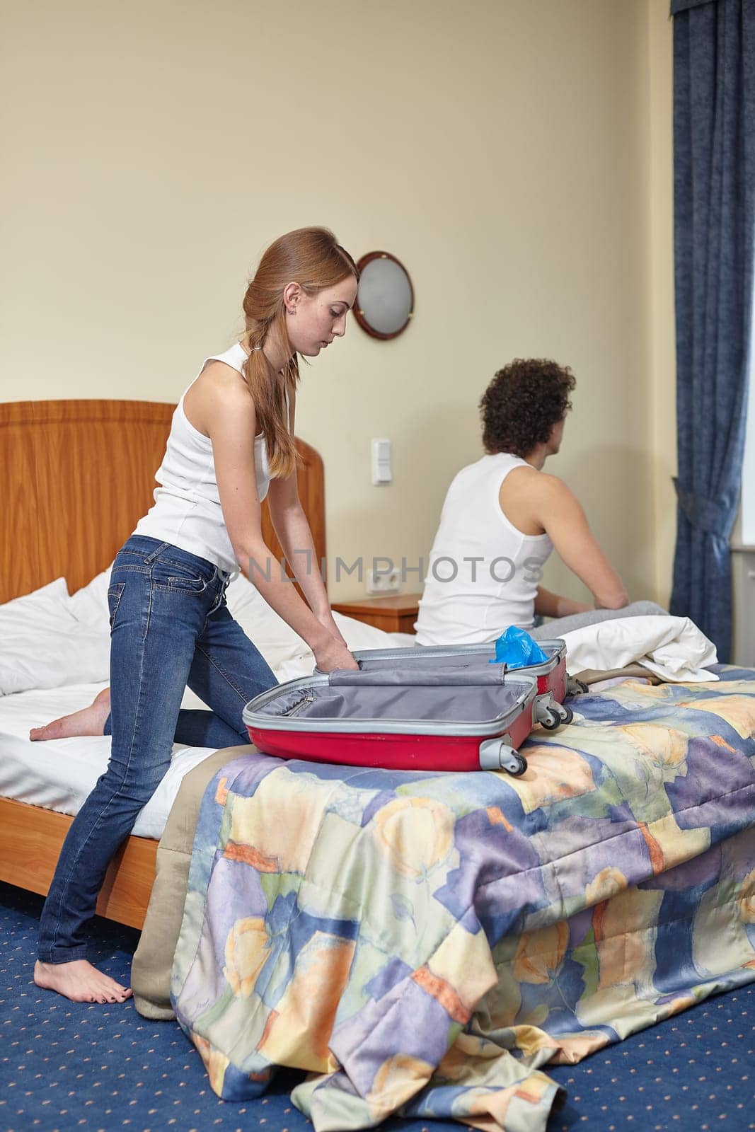 Family problems.  Divorce. Young woman packing  things in suitcase is going to leave the husband. Family conflict. Selective focus on woman