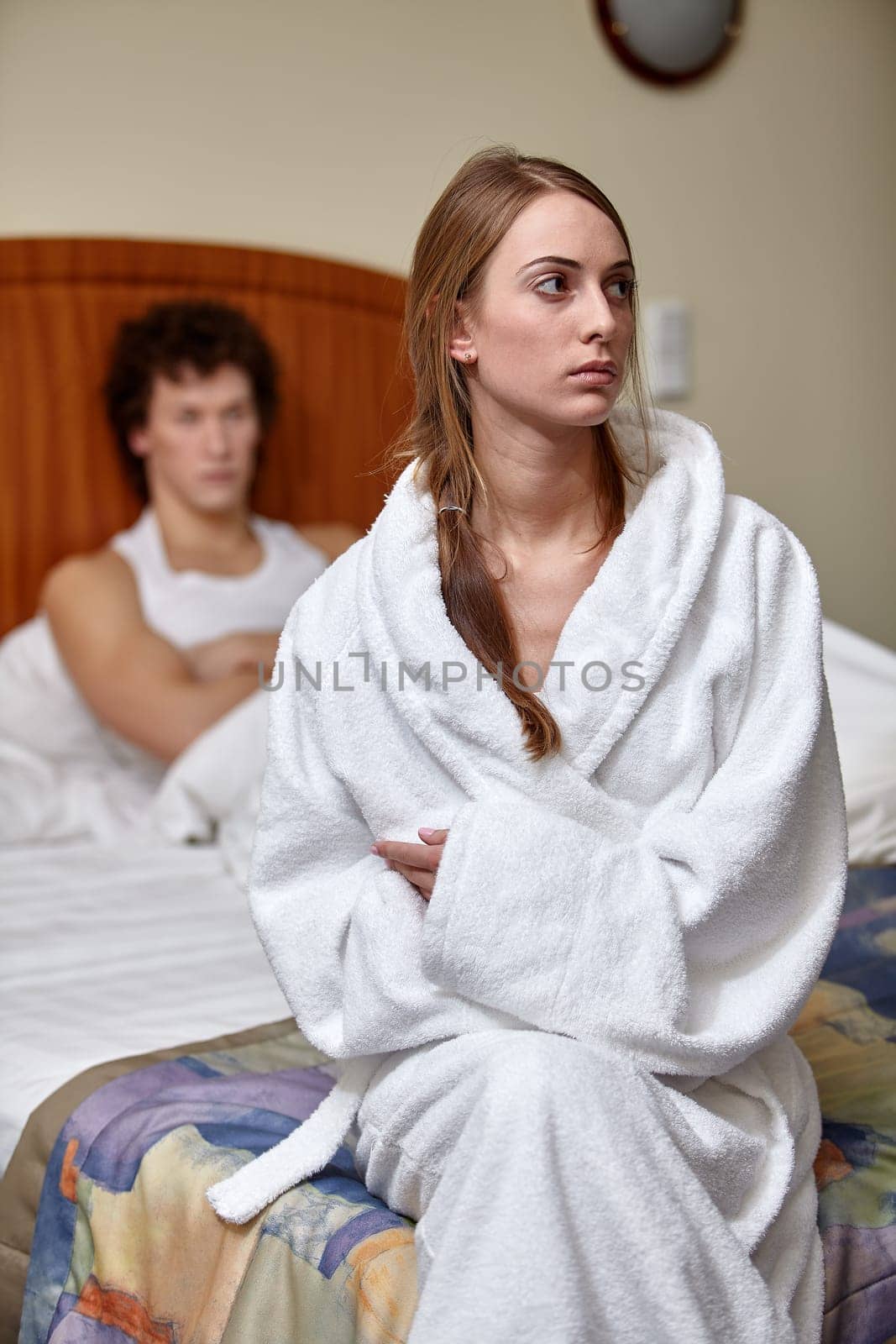 Family problems. Young couple quarrels in bedroom at home. Family conflict. Selective focus on woman