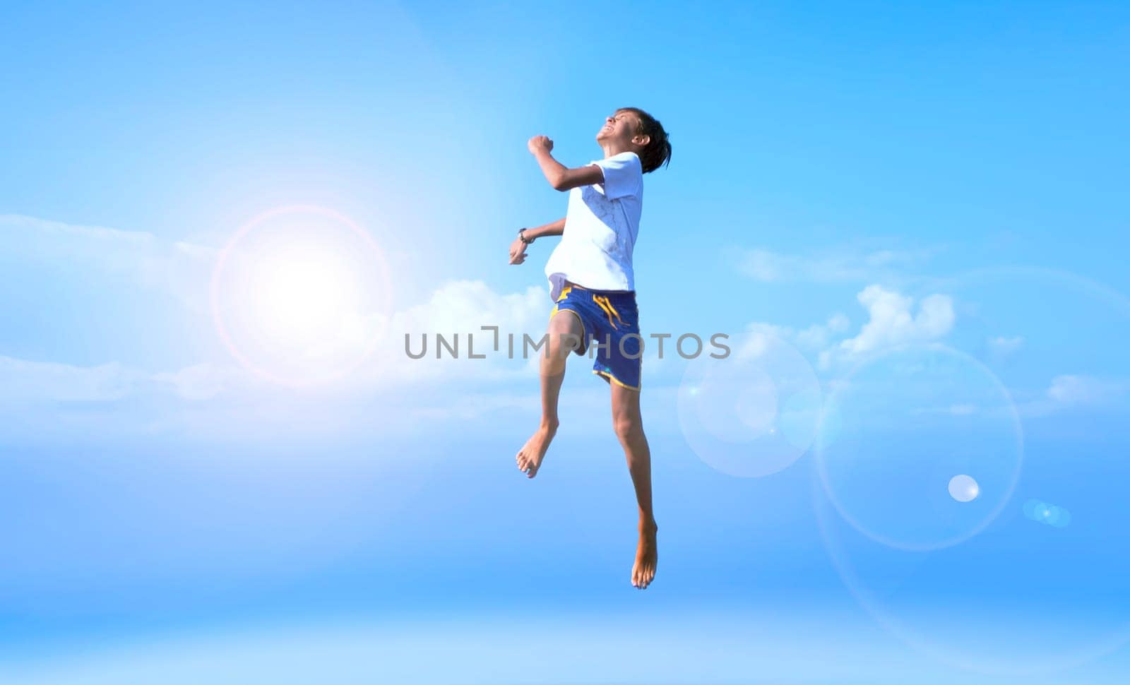 A boy jumps on a summer background of blue sky. Happy, joy, good mood