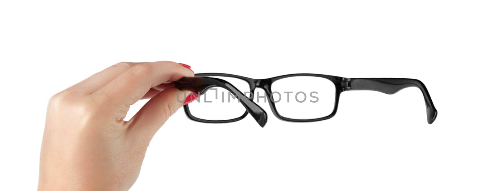 Female hand holding a black-framed glasses isolated on white background