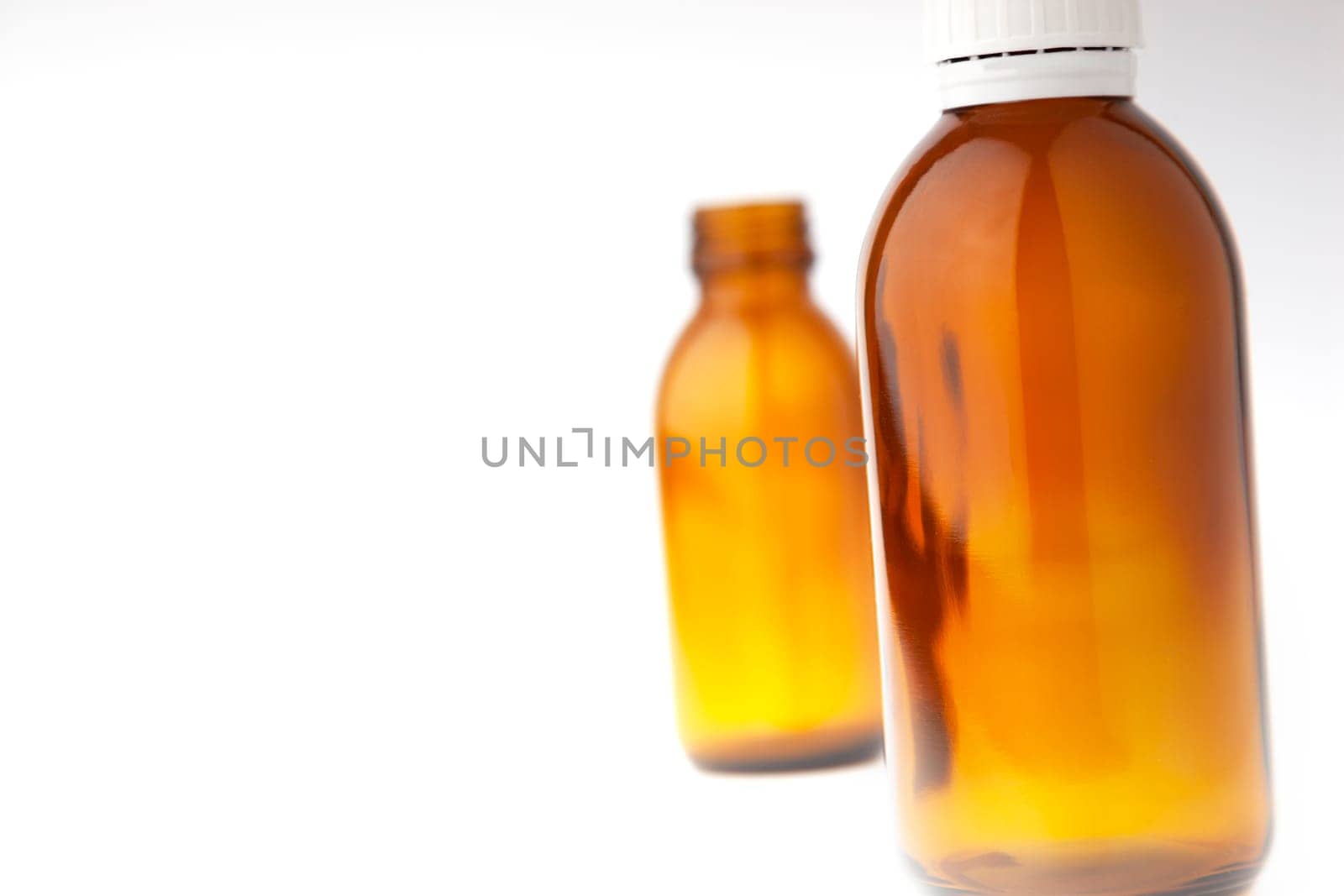 Selective focus two medicine bottles close up isolated on white background.