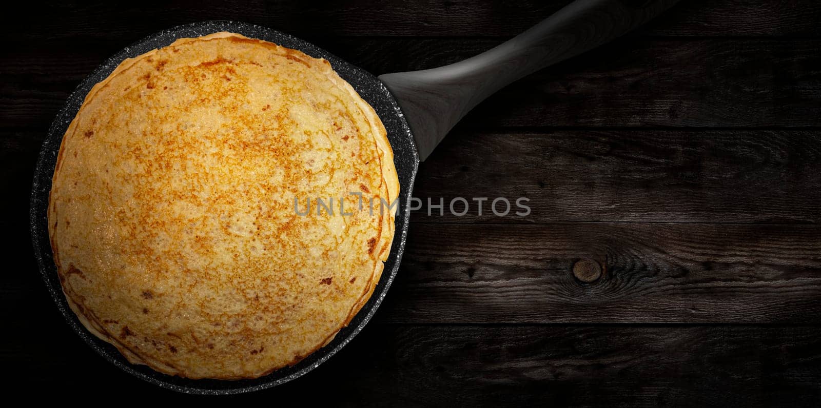 Homemade pancakes on a pan on a wooden plank. Pancake week. Delicious breakfast. View from the top.