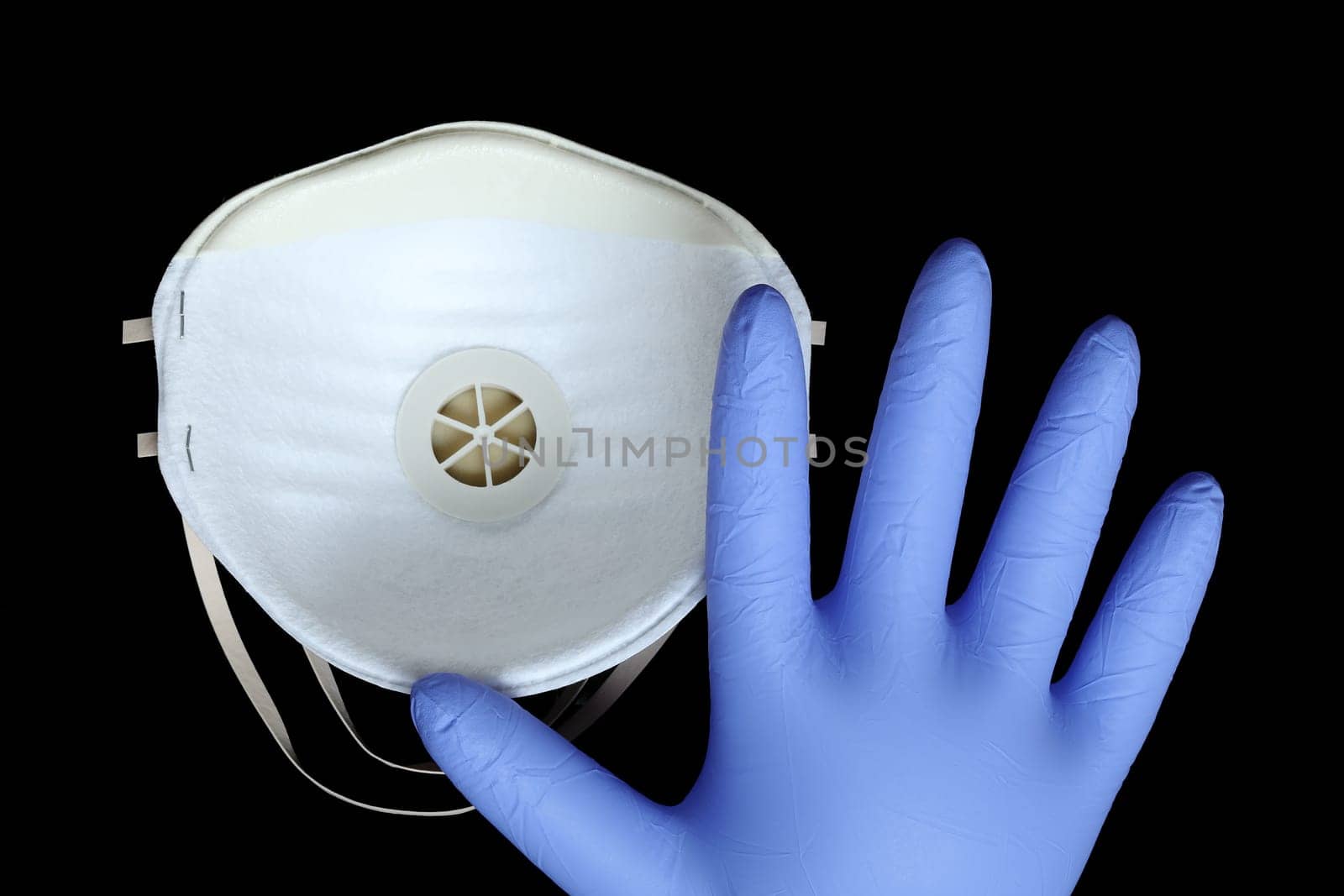 White Surgical Mask FFP2 And Blue Gloves To Protect Against Virus Infection Coronavirus COVID-19, Isolated On Black Background, Close Up View