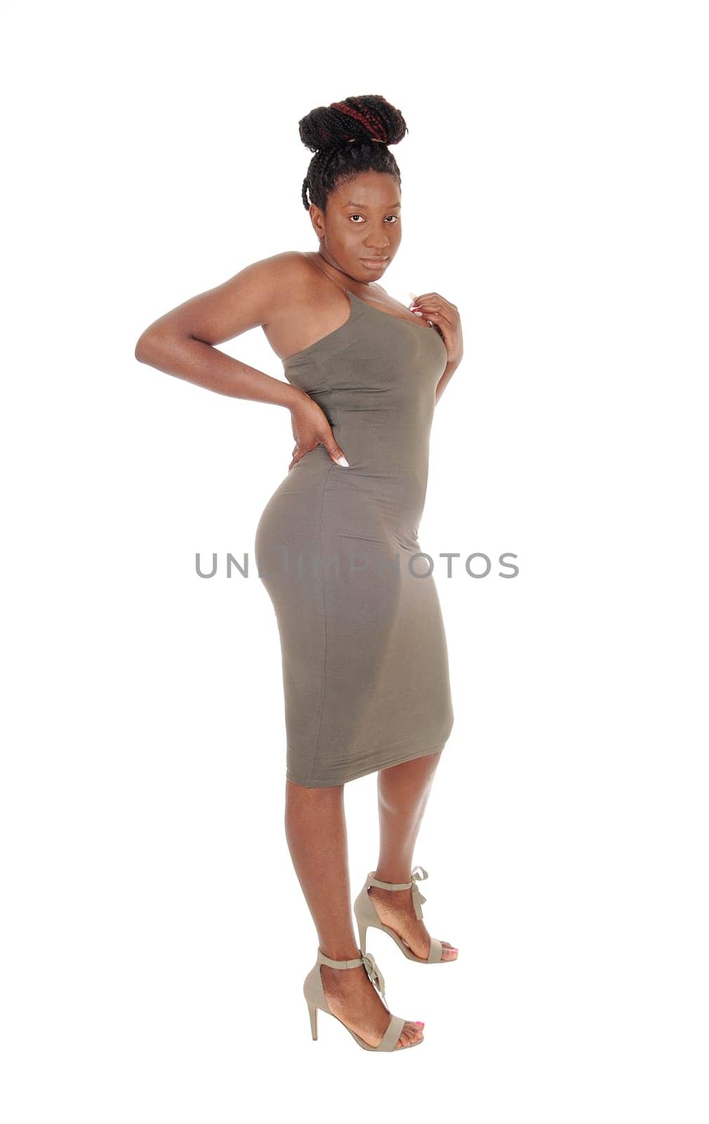 A beautiful young curvy African American female standing in a tight.gray dress, showing her figure, isolated for white background.