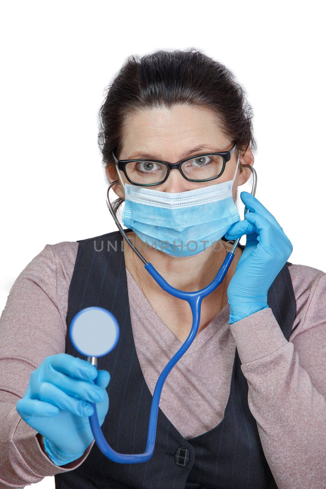 A woman in a mask and gloves with a phonendoscope in her hands with an anxious and attentive look. Self-isolation and self-control.