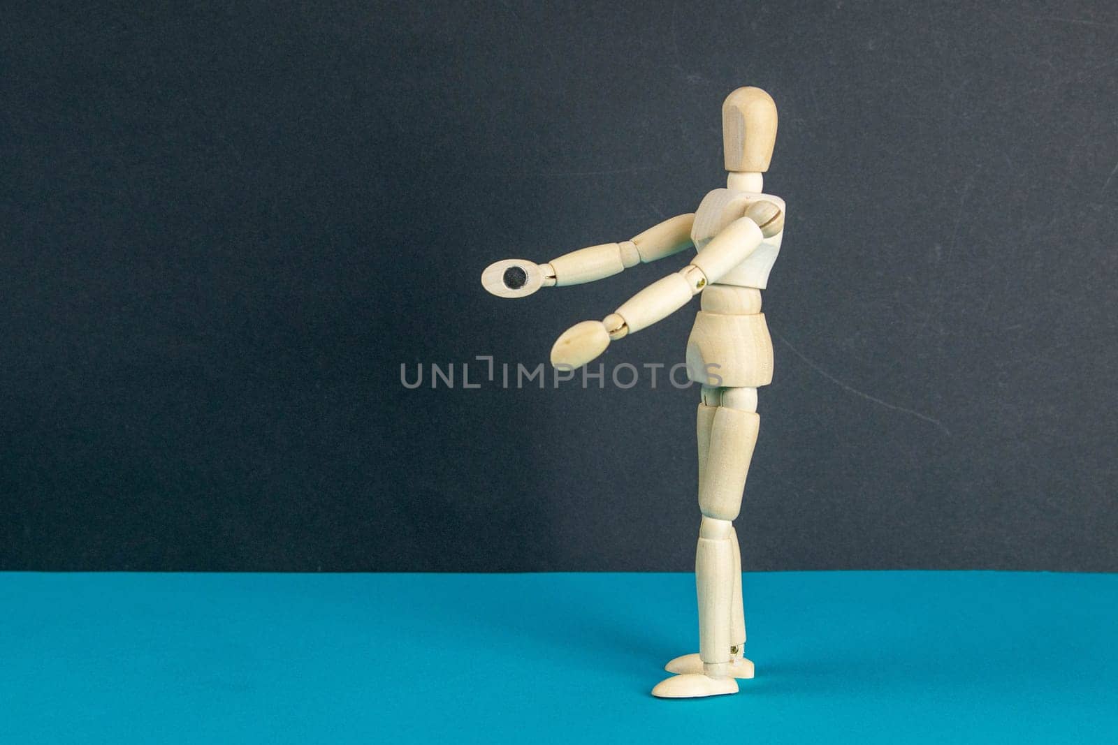 The figure of a wooden man stretches his arms forward, he wants to hug someone. The concept of loneliness, the need for attention. Close-up