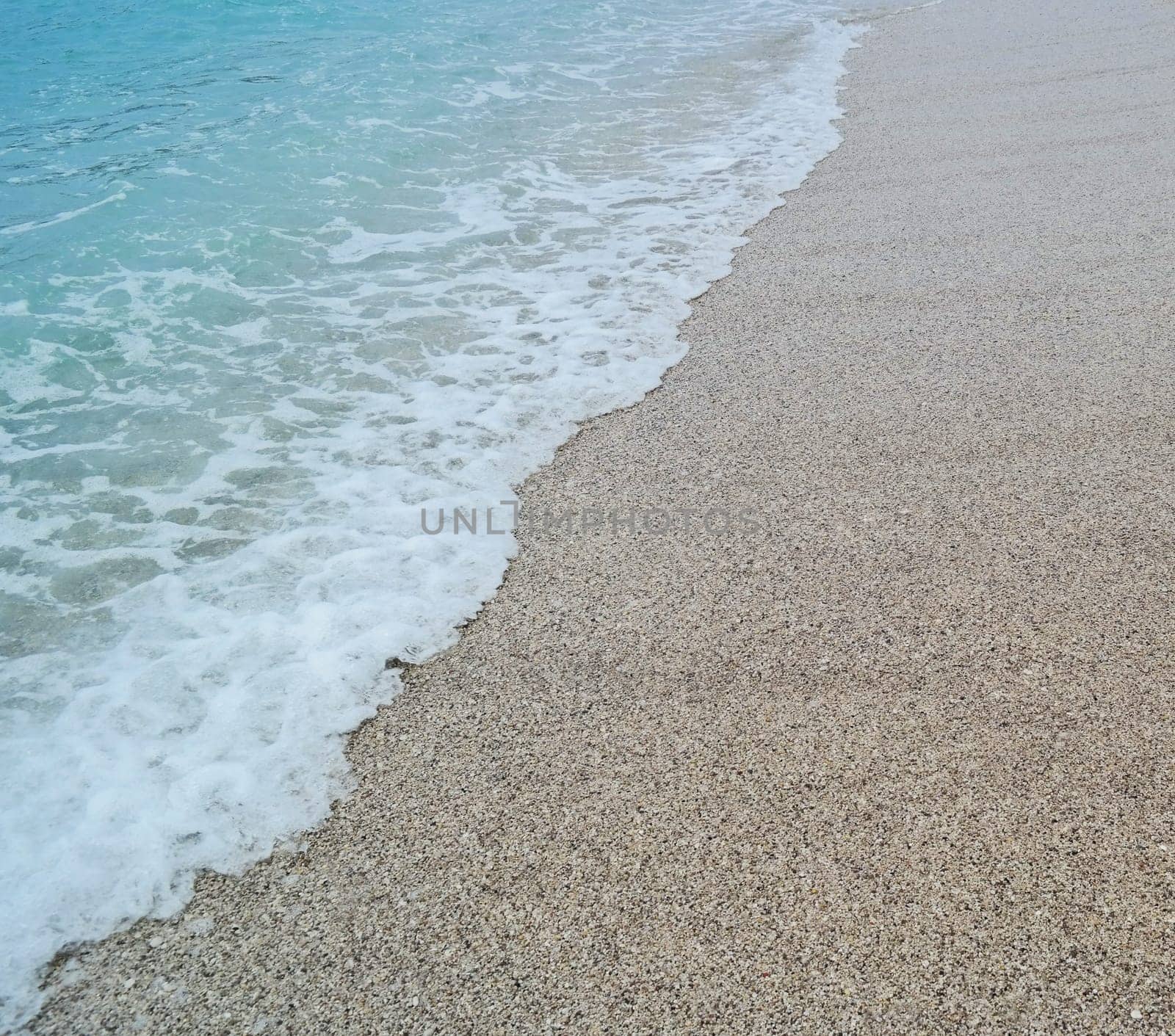 sand beach and blue wave sea with white foam