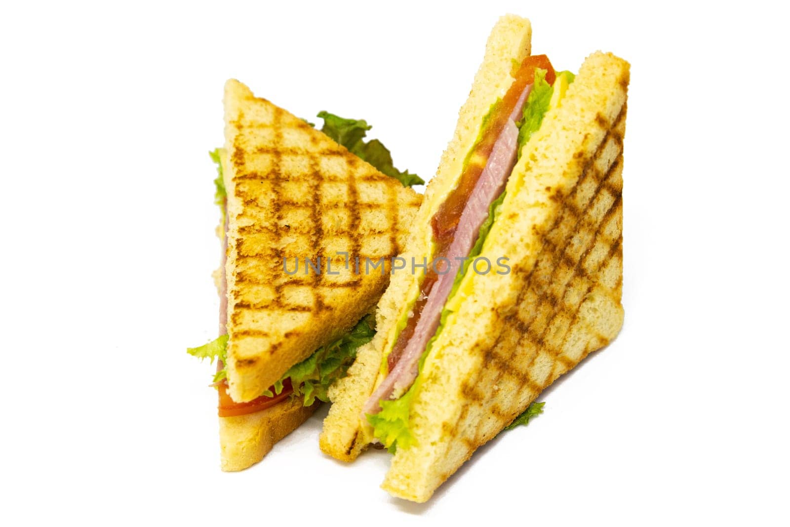 Sandwich with ham, cheese, tomatoes, lettuce, and toasted bread. Front view isolated on white background.