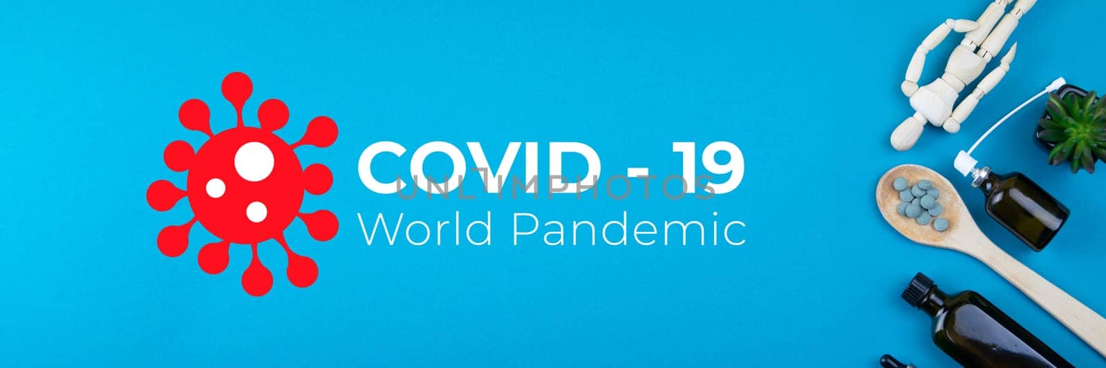 Wooden toy figure with pills on a spoon on blue background. Various capsules, tablets and medicine against Covid-19 World pandemic.