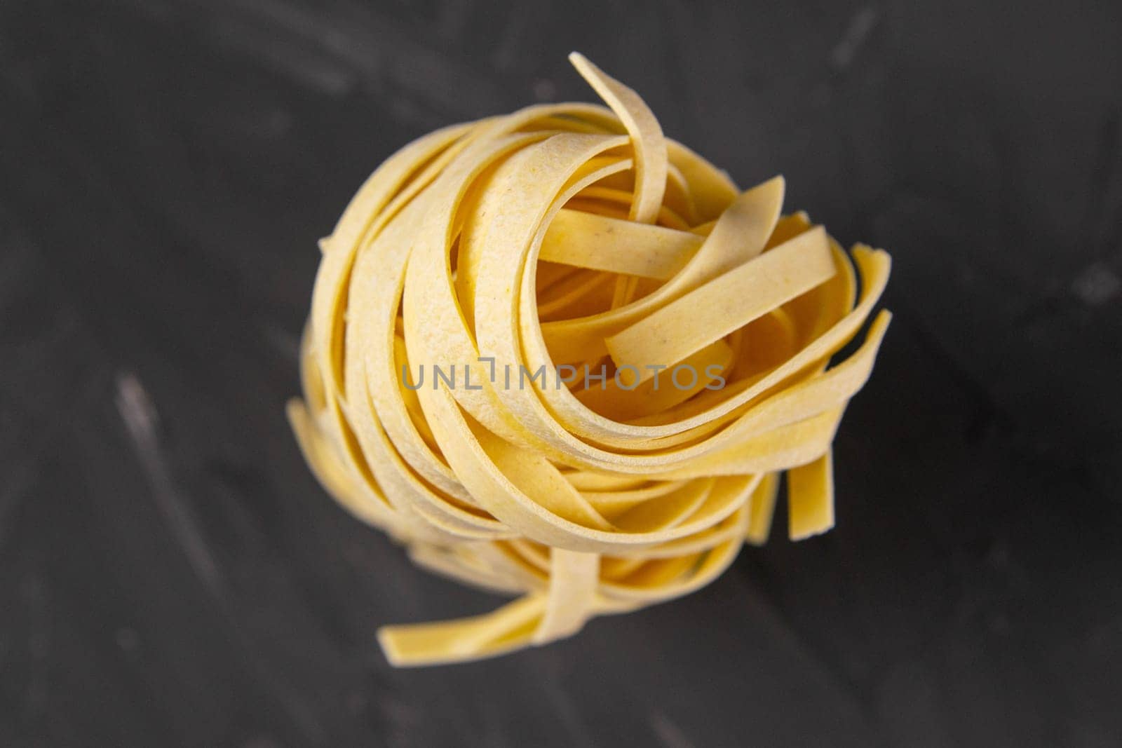 column raw dry nest pasta with reflection isolated on black. Top views