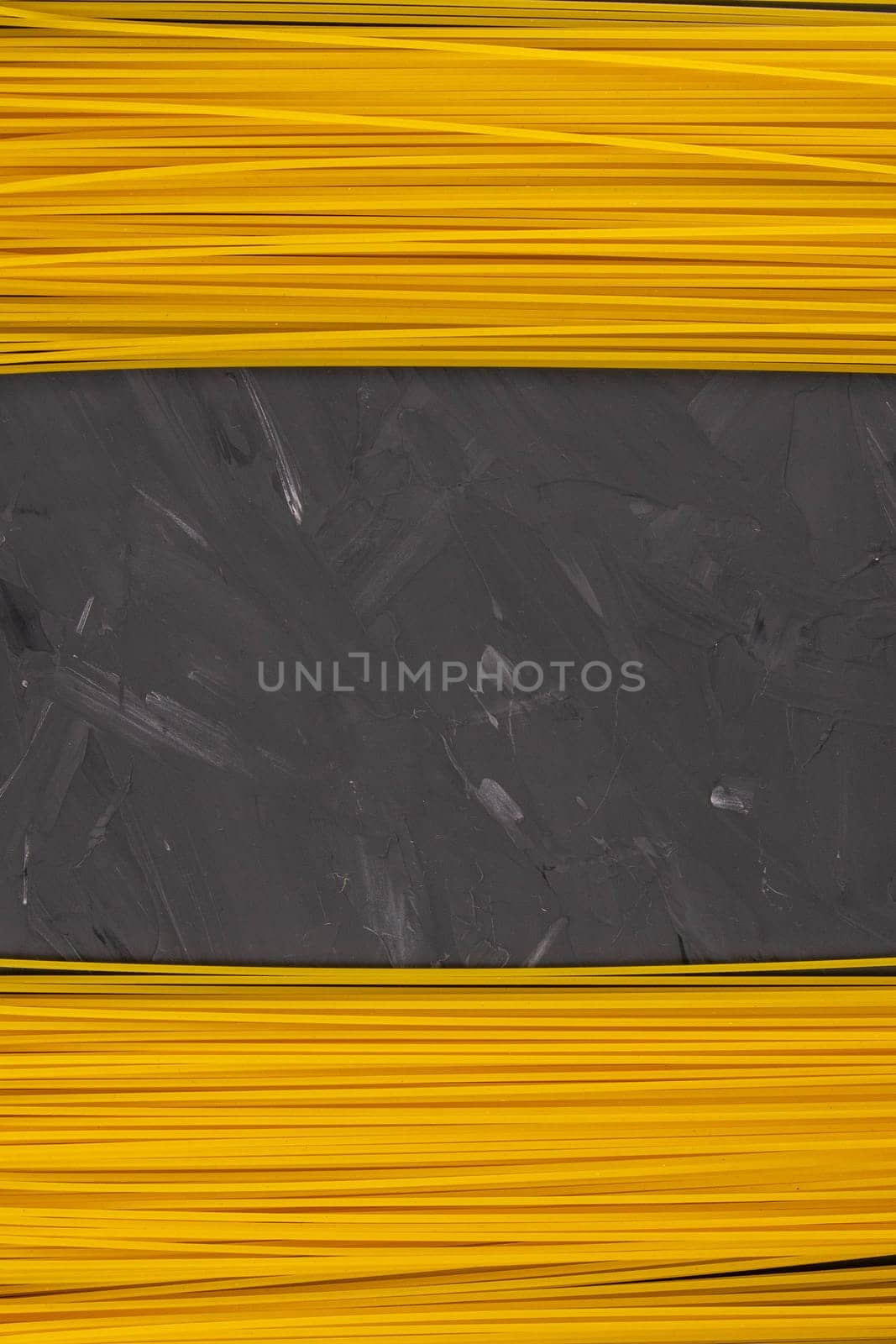 Yellow long spaghetti on a dark background. Top views with clear space