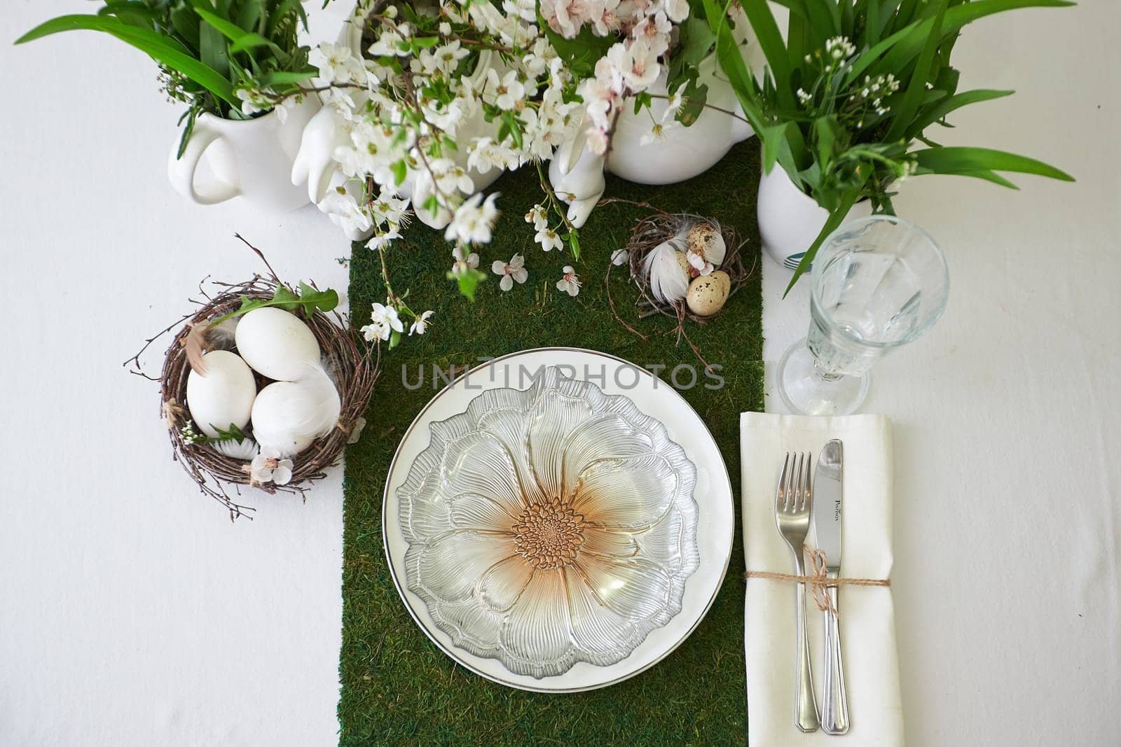 Easter table set. Decorated with eggs, nests and flowers.