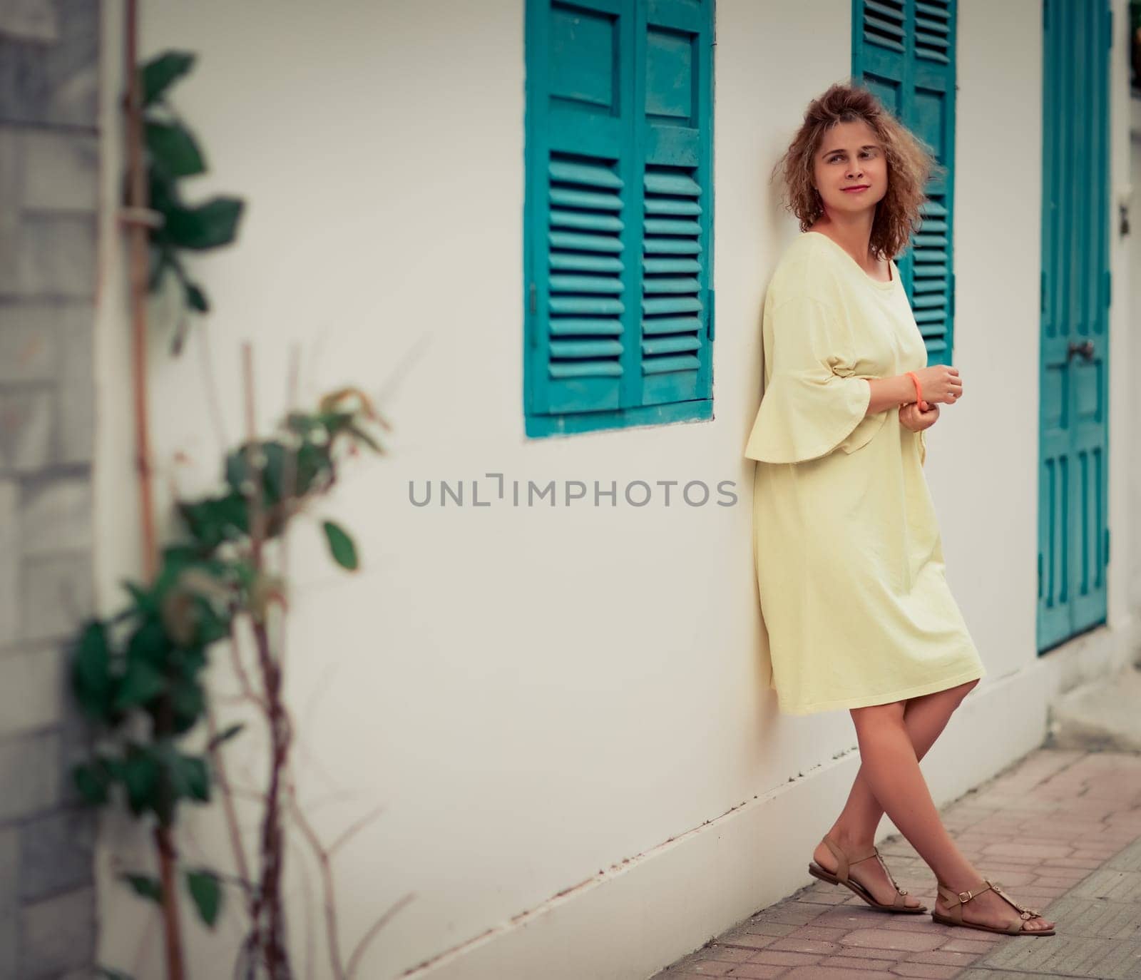 Outdoor portrait of a beautiful woman next to shutter window