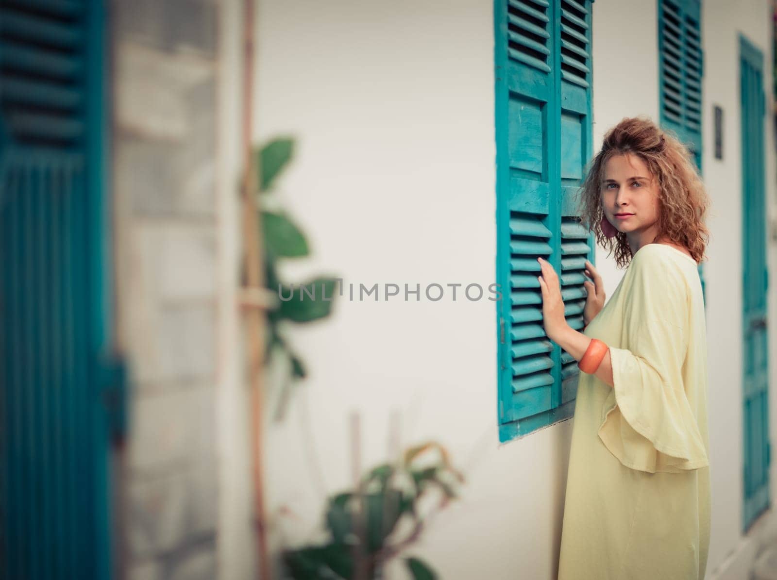 Outdoor portrait of a beautiful woman next to shutter window
