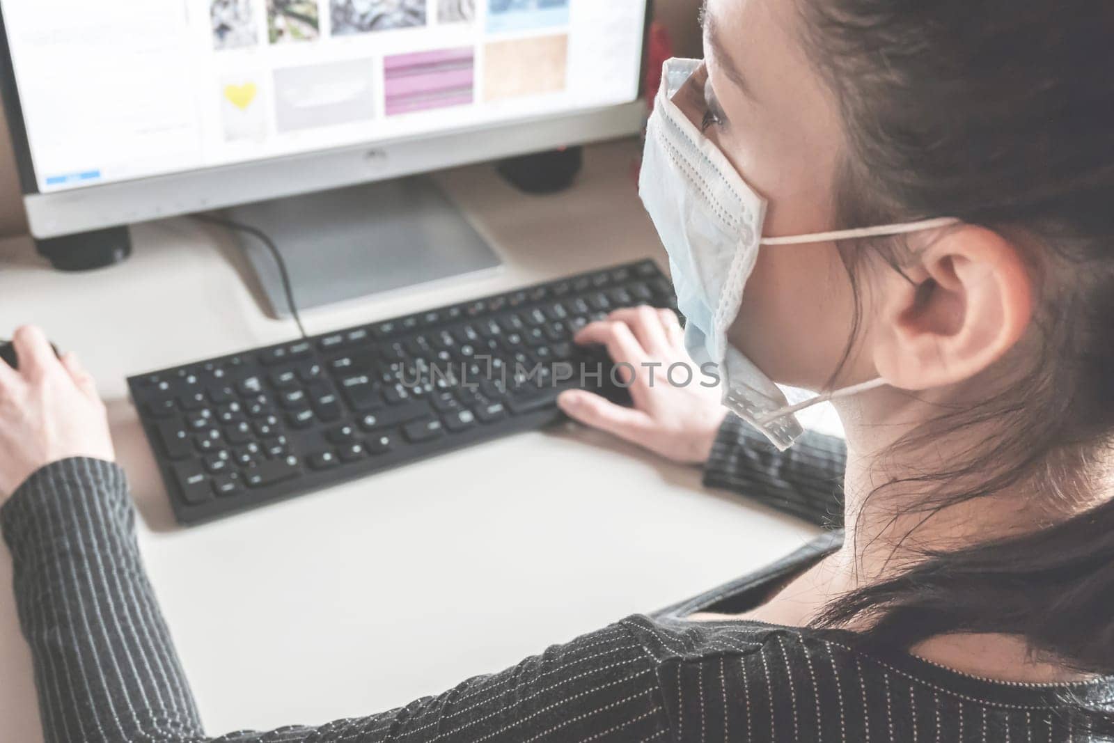 Young business woman working from home wearing protective mask. Coronavirus. Business woman in quarantine for coronavirus wearing protective mask. Working from home.