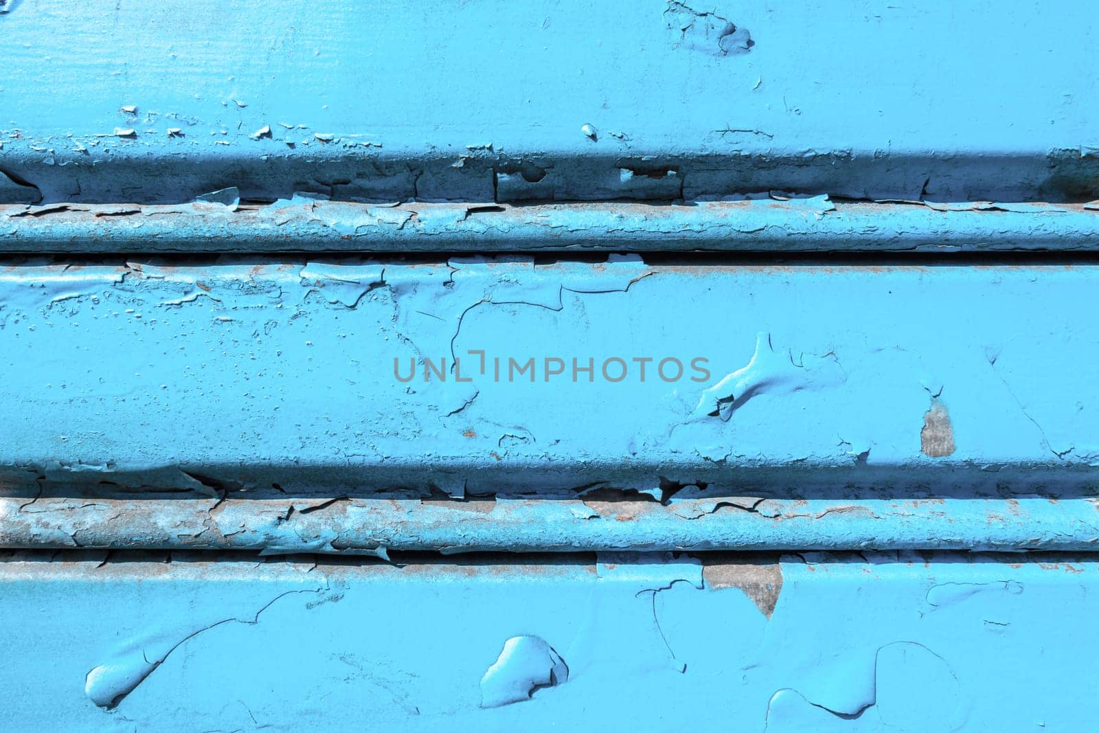 Background of old metal sheet with peel paint texture surface. Painted metal roller shutters door with peeling paint dirty blue hue. Grungy background texture.