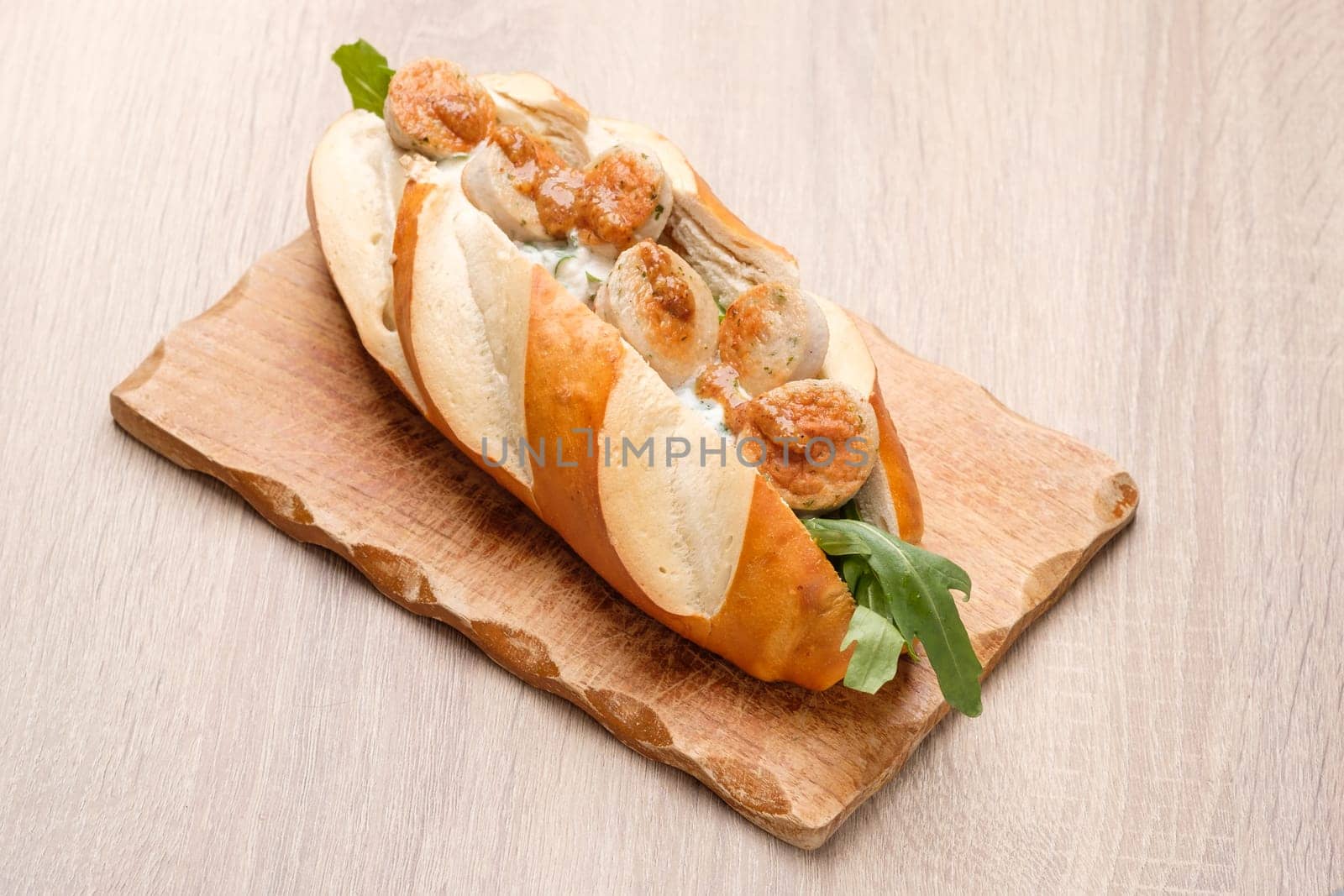 Sandwich with veal sausage and sweet mustard on wooden board