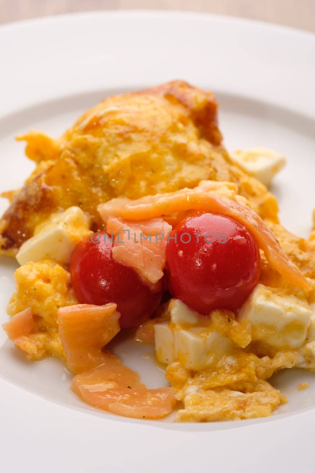 Red tomatoes with smoked salmon, cheese and scrabled eggs in portrait format