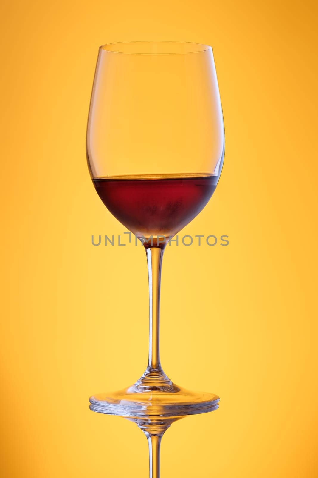 Sweet dessert wine in a glass in yellow back lit vertical format