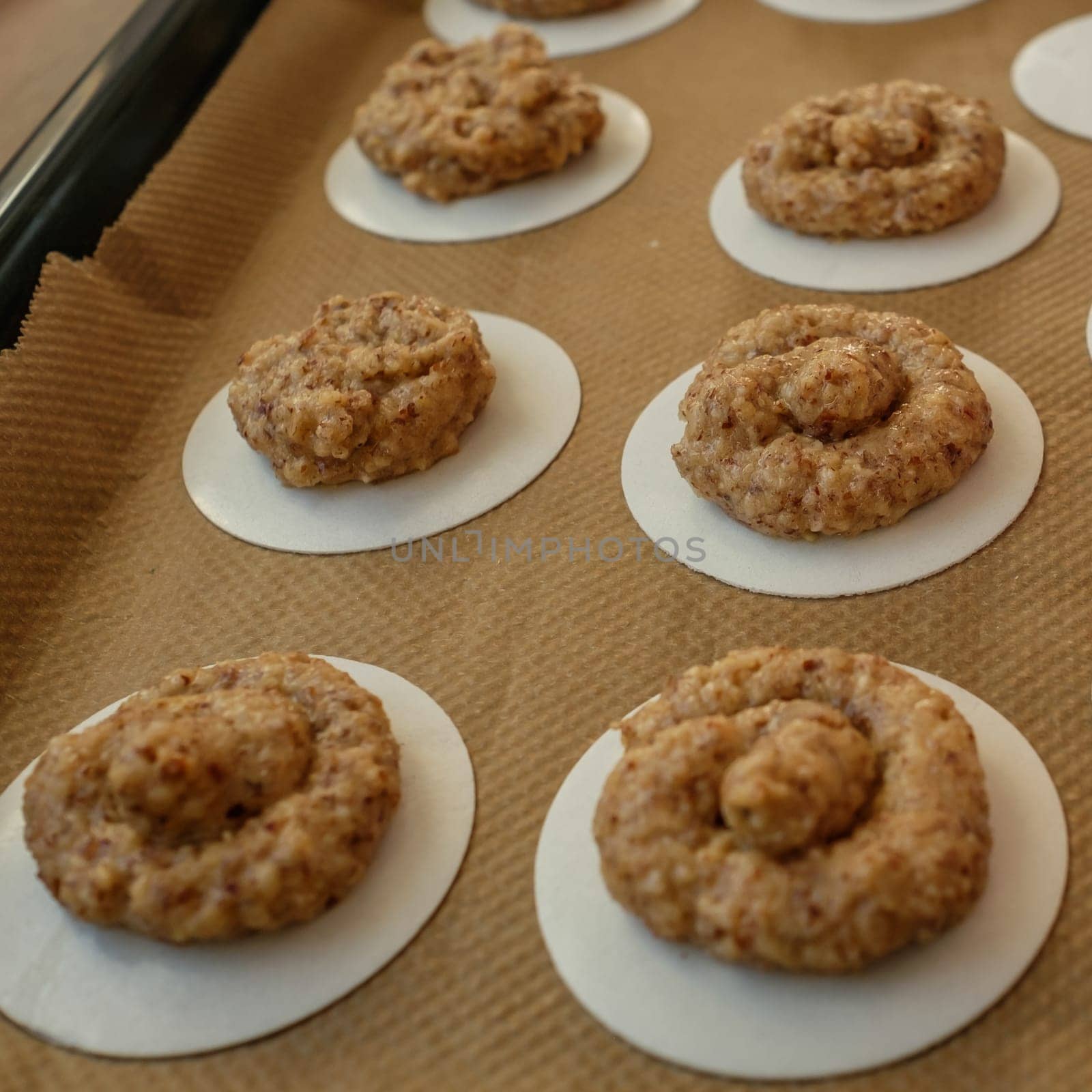 Hazelnut macaroons raw on backing paper and griddle