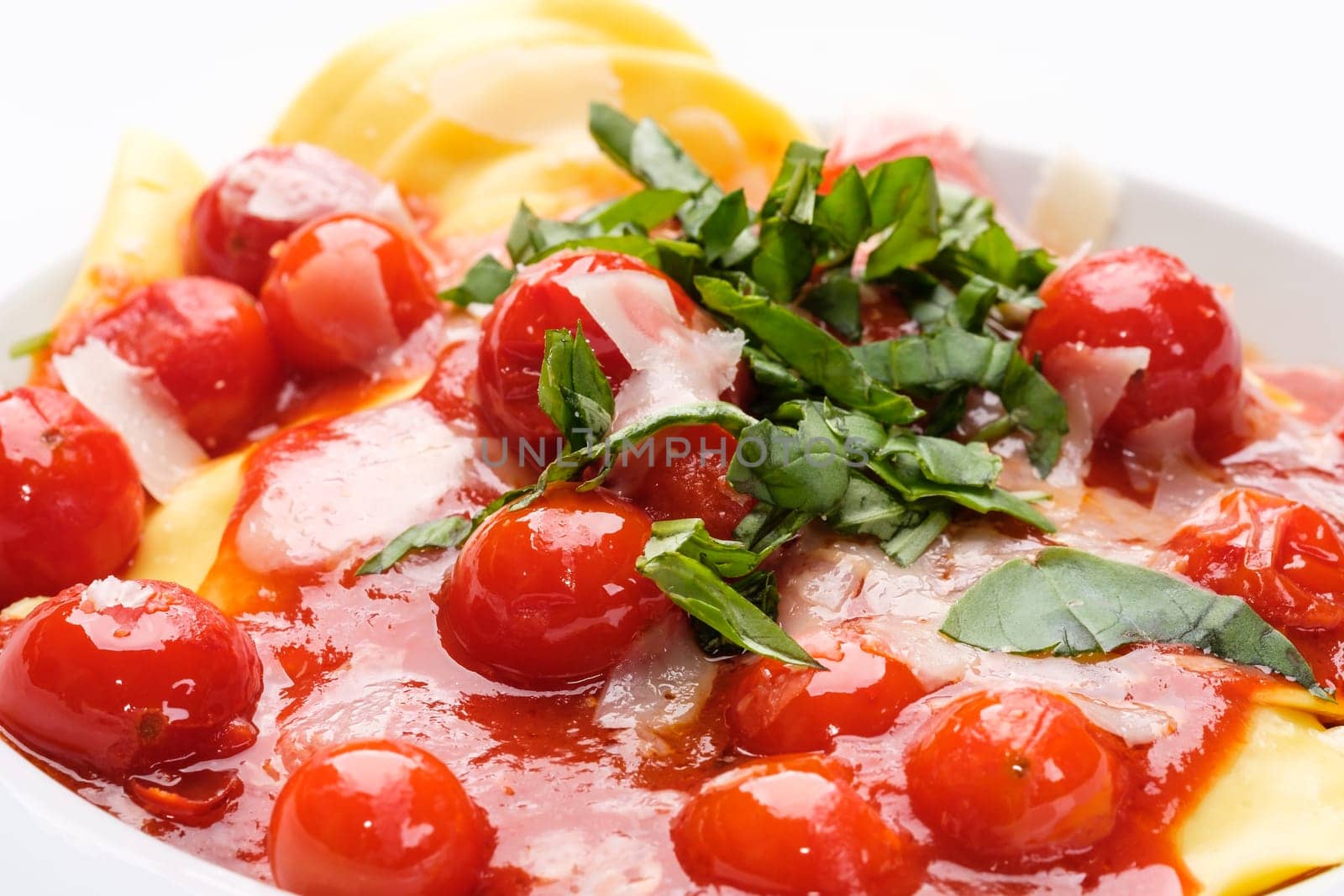 Cherry tomatoes tomato sauce with basil and parmesan on tortellini pasta