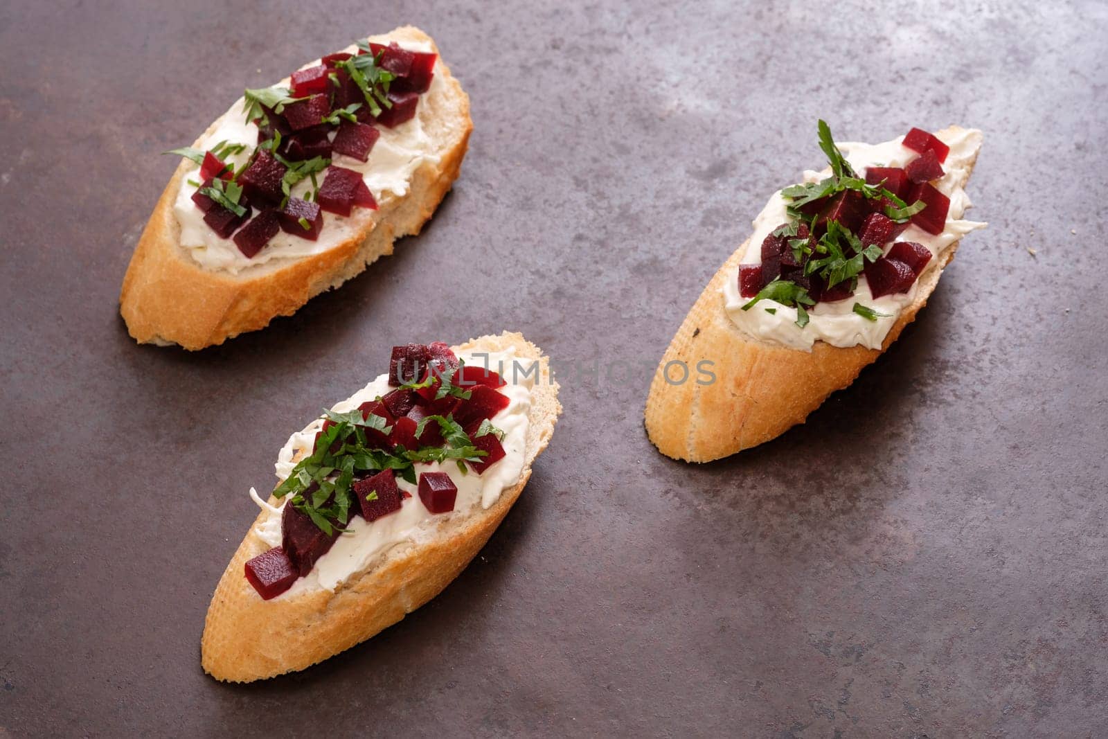 Bruschetta slice of breat with farmers cheese parsley and beetroot