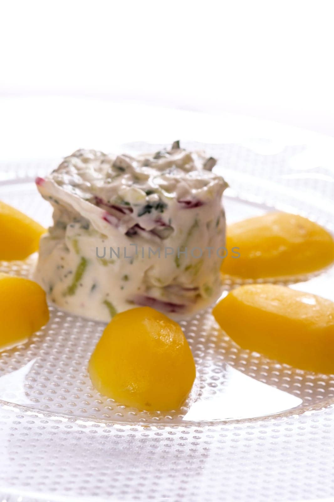 Potatoes and curd on glass plate in vertical format